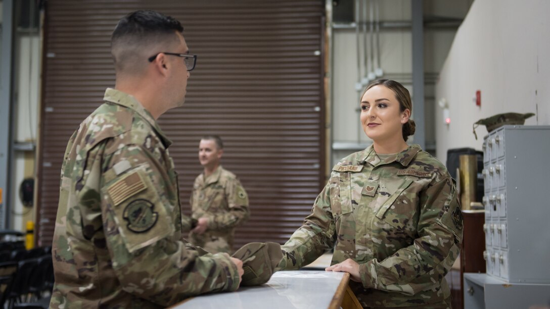 U.S. Air Force Tech. Sgt. Carly Picciano, 386th Expeditionary Force Support Squadron Personnel Support for Contingency Operations NCO-in-charge, helps an Airman at Ali al Salem Air Base, Kuwait, Aug. 6, 2019. Picciano is deployed from Dyess Air Force Base, Texas. (U.S. Air Force photo by Tech. Sgt. Daniel Martinez)