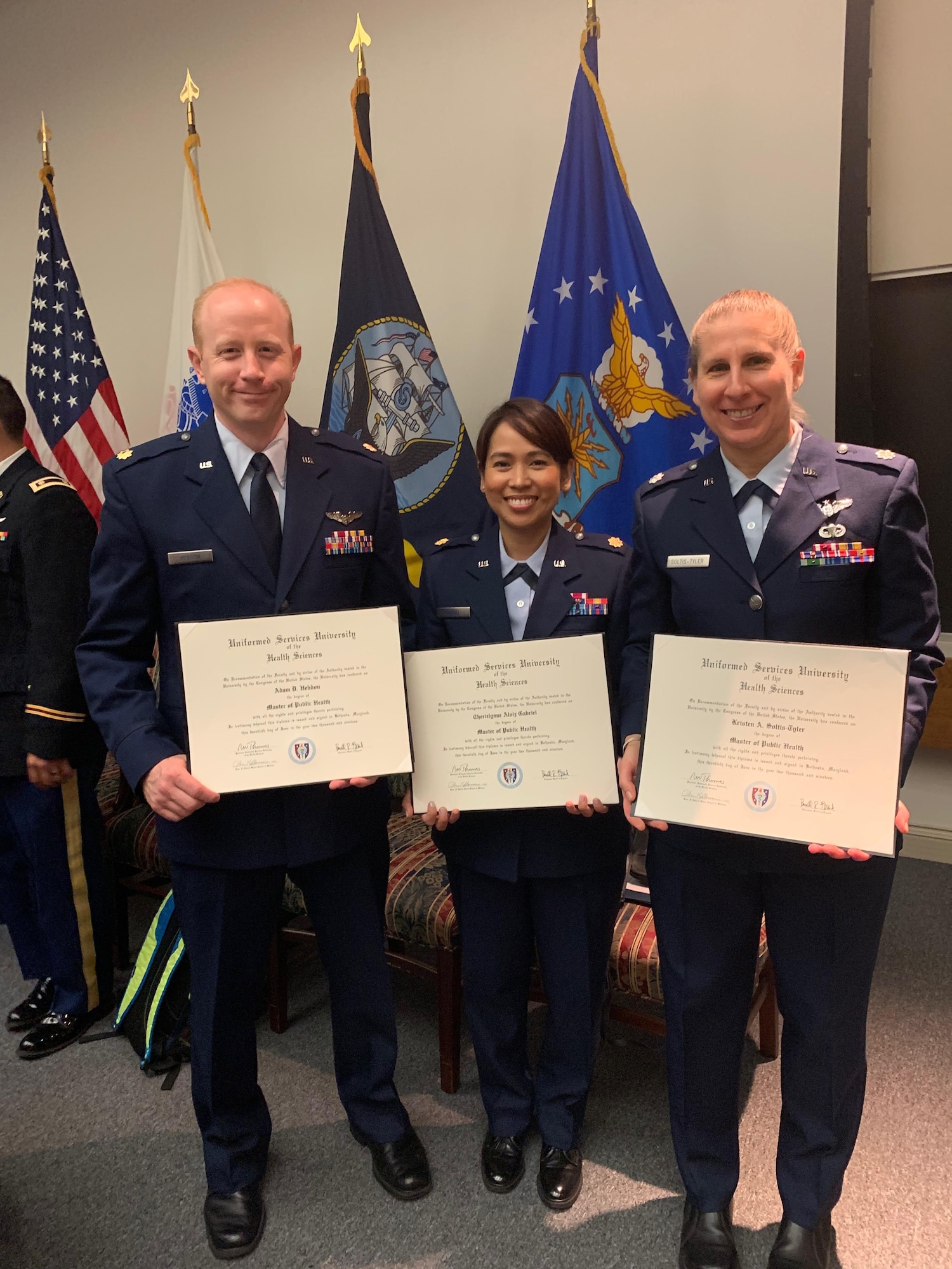 From left, U.S. Air Force Maj. Adam Hebdon, Maj. Cherielynne Gabriel, and Lt. Col. Kristen Soltis-Tyler  pose after receiving their Master in Public Health degrees from the Uniformed Services University of the Health Sciences in Bethesda, Maryland, June 20, 2019. The graduates will go on to be International Health Specialists at U.S. Air Force Air Component Commands. USUHS’s MPH program offers a concentration in Global Health, equipping graduates with the skills they need as IHSs. (Courtesy photo)