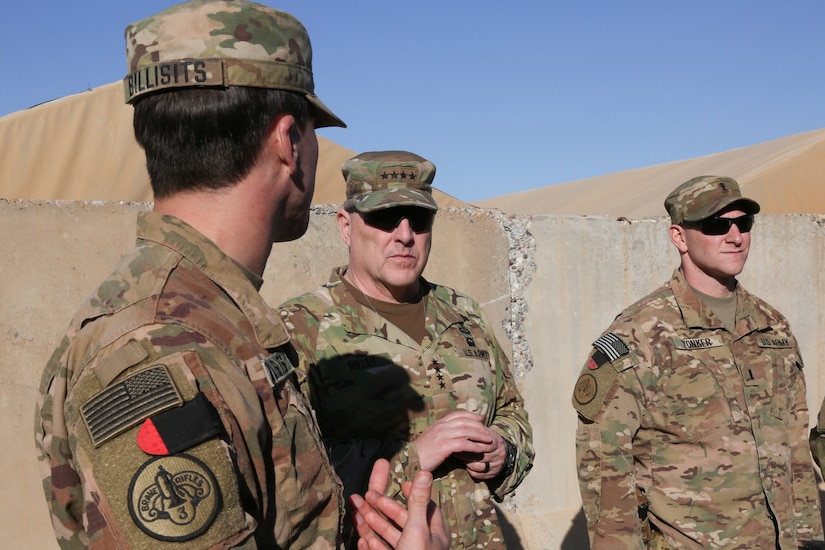 Soldiers speak in desert.