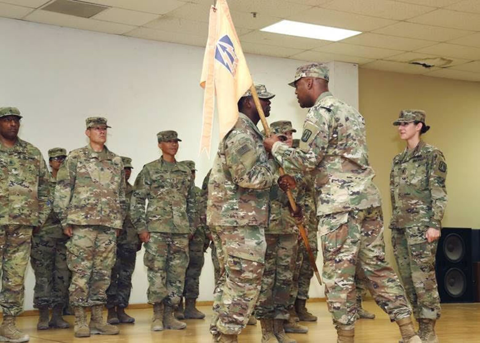 Brig. Gen. Dion B. Moten, commanding general 335th Signal Command (Theater)(Provisional), passes the colors to Capt. William A. Brinson, incoming commander Headquarters and Headquarters Company (HHC), 335th SC (T)(P), during a combined Change of Command and Change of Responsibility Ceremony at Camp Arifjan, Kuwait, August 2, 2019.  The change of command ceremony is a tradition that represents a transfer of responsibility, authority and accountability from one individual to another.