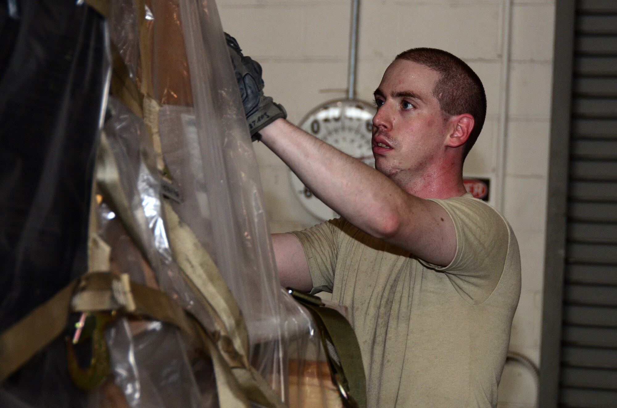 Senior Airman Matthew Ferhman, 87th Aerial Port Squadron air transportation journeyman, adjusts the top cargo net on a pallet in the cargo processing section at the 436th Aerial Port Squadron, Dover Air Force Base, Delaware, July 19, 2019 during his annual tour training