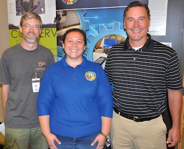 IMAGE: KING GEORGE, Va. (July 30, 2019) – Navy human factors engineer Chelsey Lawson, middle, is pictured with her former high school teachers at the Naval Surface Warfare Center Dahlgren Division (NSWCDD) STEM Workshop for Educators at the University of Mary Washington Dahlgren campus. Lawson was among the NSWCDD scientists and engineers who joined university professors at the workshop to share best practices and ideas for project based learning in STEM with elementary, middle, and high school educators. Standing left to right at the workshop is Jeremy Webb from Spotsylvania High School; Lawson; and Jim McNamee from Commonwealth Governor’s School.  “Mr. Webb was my drafting teacher and Mr. McNamee was my math teacher for three years,” said Lawson. “They were both very encouraging and influential not only in my high school education but also in choosing to be an engineer because they made STEM subjects interesting.”