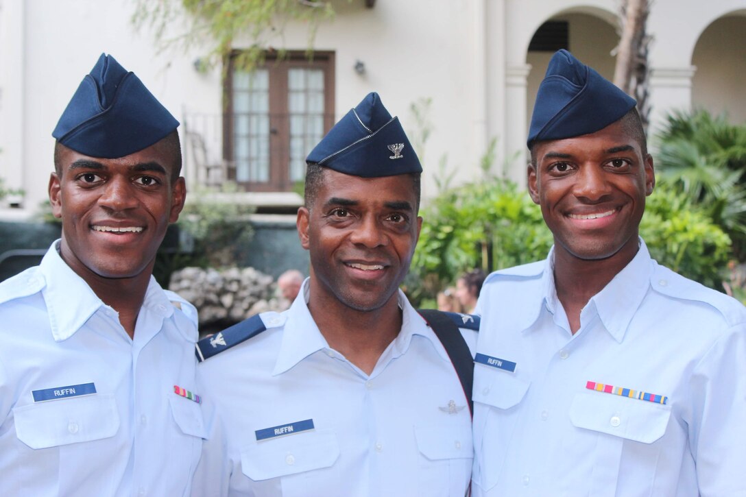 Airmen 1st Class Leernest Ruffin, left, and LeNard Ruffin, right, both 482nd Attack Squadron (ATK) intel analysts, and their father, Col. Leernest Ruffin, Headquarters United States Central Command deputy chief information officer, center, pose for a photo at basic military training (BMT) graduation at Joint Base San Antonio, Texas.