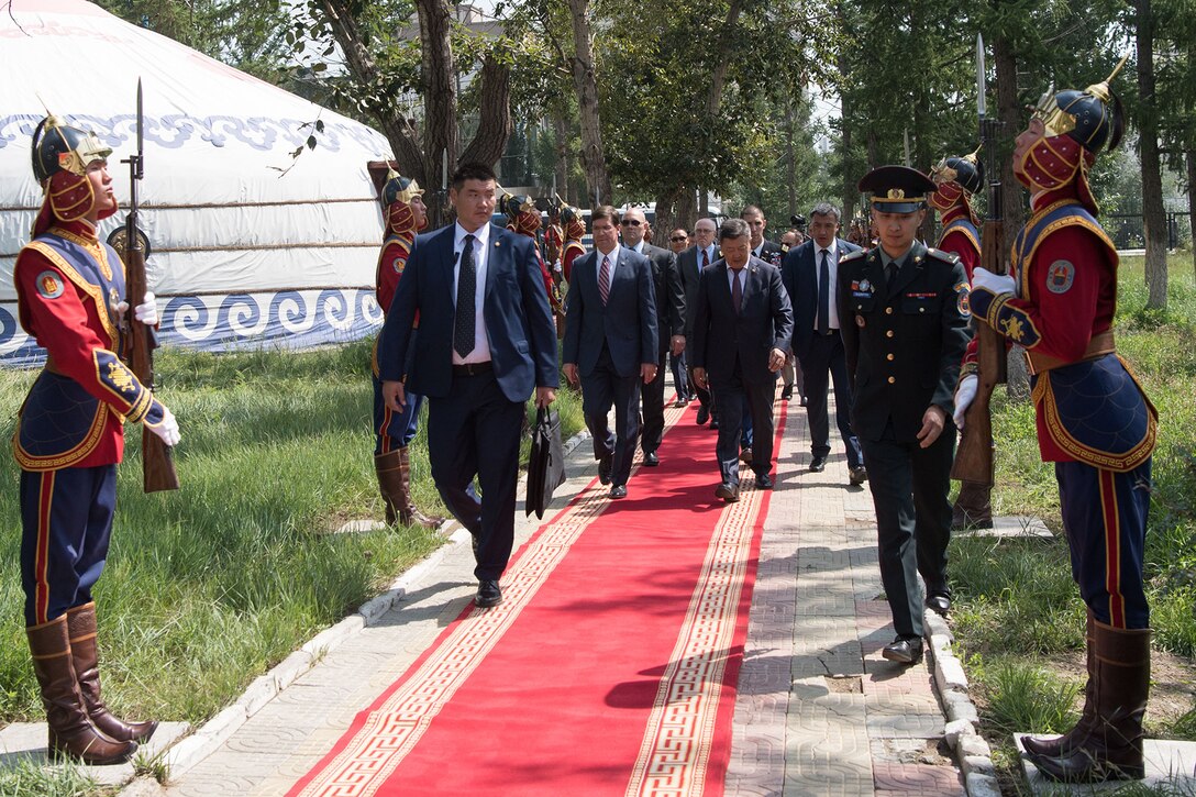 Men walk down a red carpet.