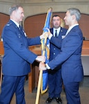 Col. Terry W. McClain, 433rd Airlift Wing commander, presents the wing guidon to San Antonio Mayor Ron Nirenberg during an honorary commander induction ceremony Aug. 8 at the San Antonio City Council chamber. The honorary commander program matches military commanders with local business and civic leaders to foster and grow understanding of the military mission and its impact on the surrounding community.