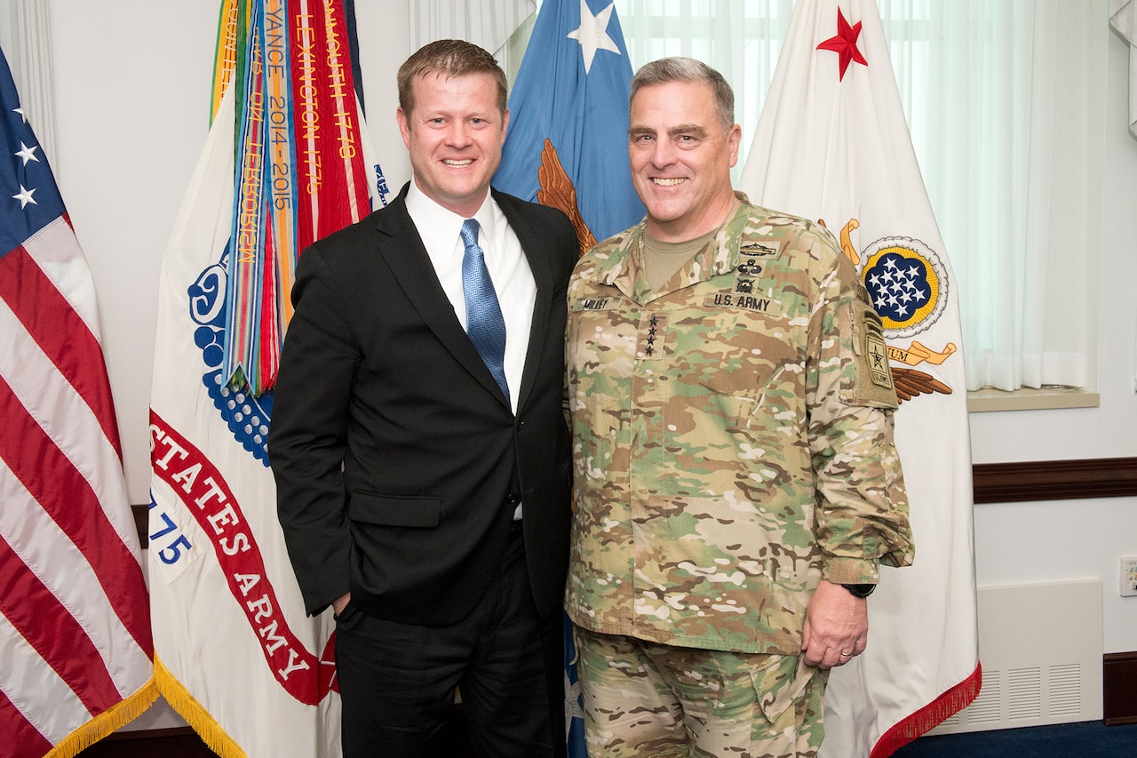 Men stand in front of flags.