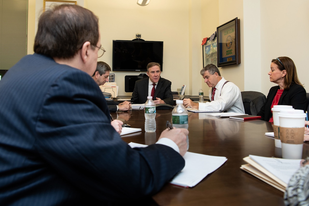 A group of people sitting at a desk.