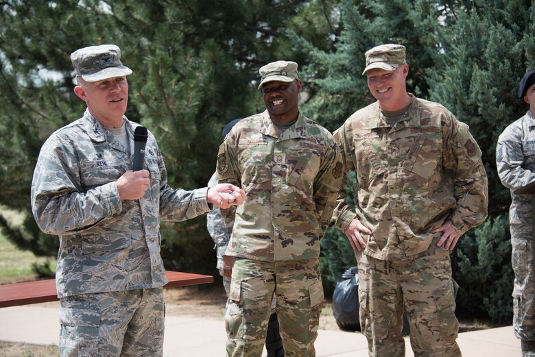 Col. Brian Kehl (left), 50th Mission Support Group commander, address Airmen during the chaplain’s office spiritual resiliency picnic at Schriever Air Force Base, Colorado, July 25, 2019. During the event, Kehl recognized the outstanding leadership of Senior Master Sgt. Cory Shipp (center), 50th Force Support Squadron superintendent. Kehl also gave farewell remarks for Chief Master Sgt. Daniel Tester (right), 50th MSG chief enlisted manager, who will retire from the Air Force in the coming months. (U.S. Air Force photo by 2nd Lt. Idalí Beltré Acevedo)