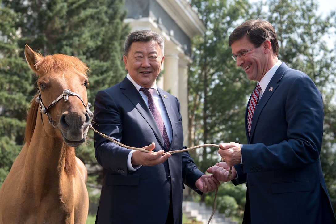 Two men stand next to a horse.