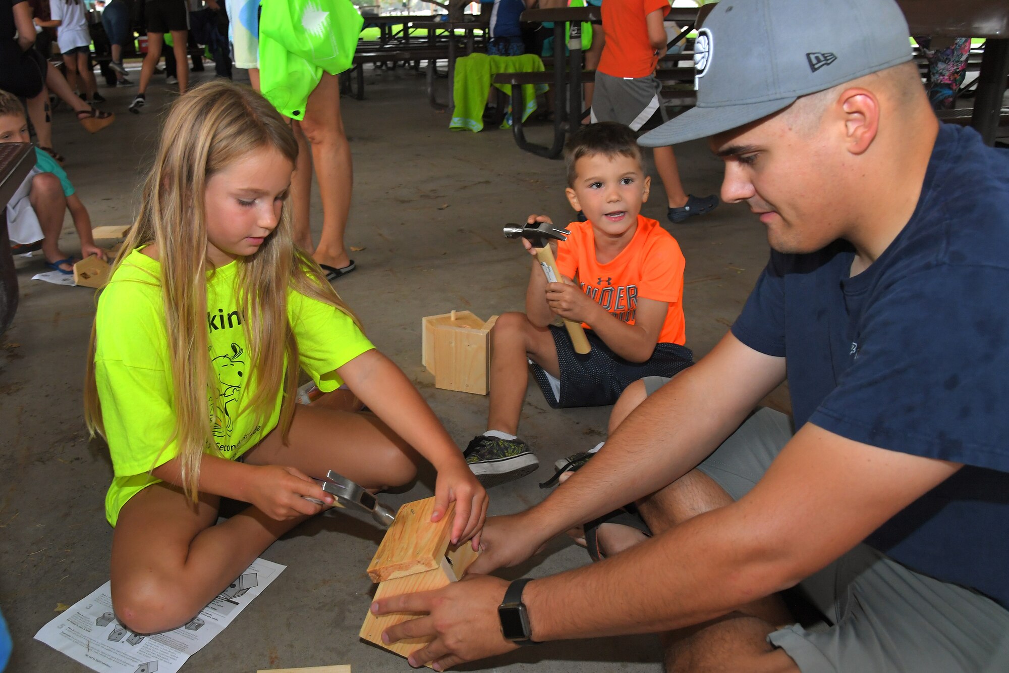 (Left to right) Paisley and Ricky build birdhouses with their father Tech. Sgt. Ricky Rea, 388th Aircraft Maintenance Squadron weapons load crew chief, during the Kickin’ It for Conservation energy and environmental fair Aug. 8, 2019, at Hill Air Force Base, Utah. Although officially celebrated in April, the event served as the base’s commemoration of Earth Day and was an opportunity for children and adults to learn how to conserve energy and protect the environment. (U.S. Air Force photo by Todd Cromar)