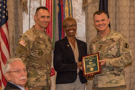 Gen. Paul E. Funk II, commanding general, U.S. Army Training and Doctrine Command, and TRADOC Command Sgt. Maj. Timothy A. Guden, pose for a photo with Dr. Evelyn Hollis, the 2019 Educator of the Year during the TRADOC Instructor of the Year Awards Ceremony at Fort Eustis, Va., Aug. 7, 2019. The seven awardees were recognized during a ceremony held at the TRADOC Commander's Forum.  (U.S. Army photo by Gwyndolynn Giacomo)