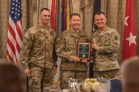 Gen. Paul E. Funk II, commanding general, U.S. Army Training and Doctrine Command, and TRADOC Command Sgt. Maj. Timothy A. Guden, pose for a photo with Capt. Matthew Weather, the 2019 Active Duty Instructor of the Year during the TRADOC Instructor of the Year Awards Ceremony at Fort Eustis, Va., Aug. 7, 2019. The seven awardees were recognized at a ceremony held during the TRADOC Commander's Forum. (U.S. Army photo by Gwyndolynn Giacomo)