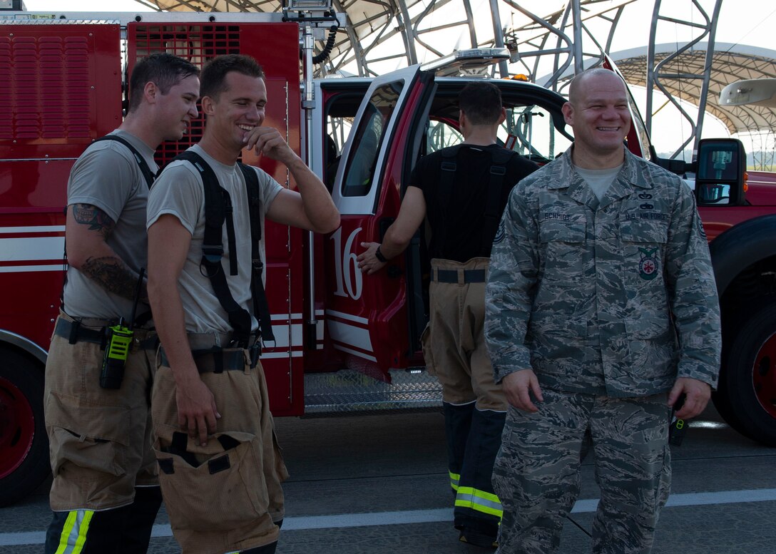 Firefighters from the 23d Civil Engineer Squadron (CES) share a laugh after completing an A-10C Thunderbolt II egress training scenario, Aug. 9, 2019, at Moody Air Force Base, Ga. The 23d CES conducted the exercise to test their capability in extinguishing an A-10 on fire while simultaneously rescuing its pilot. The training also served as an opportunity for firefighter crew chiefs and their Airmen to increase team cohesion. (U.S. Air Force photo by Airman Azaria E. Foster)