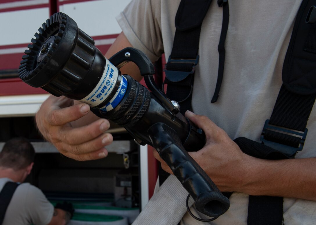 Airman 1st Class Zachary Mabee, 23d Civil Engineer Squadron (CES) firefighter, tightens a hose after completing an A-10C Thunderbolt II egress training scenario, Aug. 9, 2019, at Moody Air Force Base, Ga. The 23d CES conducted the exercise to test their capability in extinguishing an A-10 on fire while simultaneously rescuing its pilot. The training also served as an opportunity for firefighter crew chiefs and their Airmen to increase team cohesion. (U.S. Air Force photo by Airman Azaria E. Foster)
