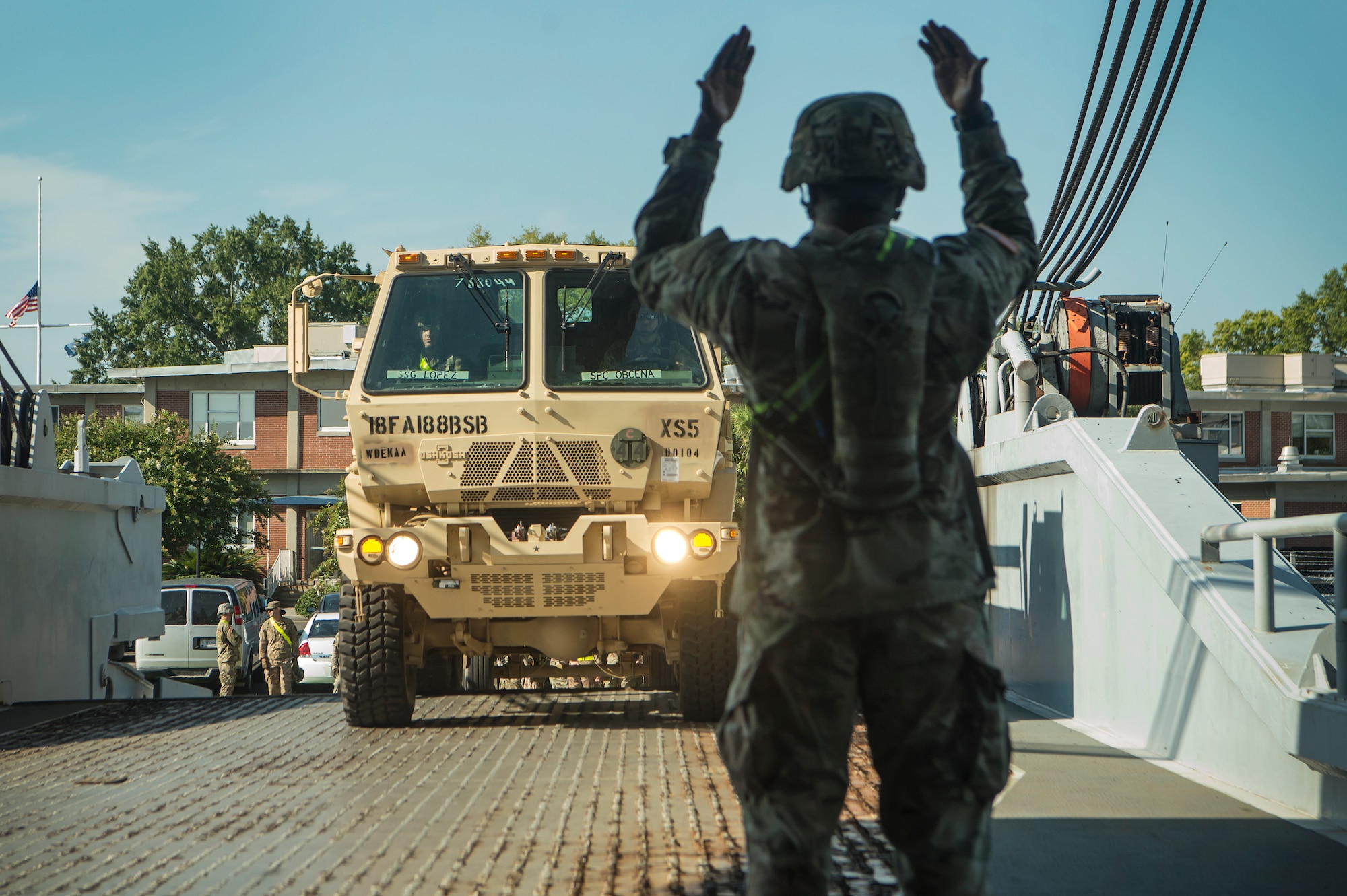 U.S. Army Staff Sgt. Conrad Stewart, a motor transport operator assigned to the 18th Field Artillery Brigade, 188th Brigade Support Battalion from Fort Bragg, N.C., directs army vehicles onto Logistics Naval Vessel Cape Decision during Exercise Dragon Lifeline Aug. 7, 2019, at the Federal Law enforcement Training Center in Charleston, S.C. The deployment readiness exercise combined the capabilities of service members from Fort Bragg, N.C., Joint Base Charleston, S.C., and Joint Base Langley-Eustis, Va., focused on the rapid deployment of equipment, vehicles and personnel. Participants shared knowledge and tested their efficiency in moving assets by air, land, rail and sea during the training event. The annual exercise is just one of the critical readiness exercises the DOD conducts to maintain a lethal and ready force. (U.S. Air Force photo by Tech. Sgt. Christopher Hubenthal)