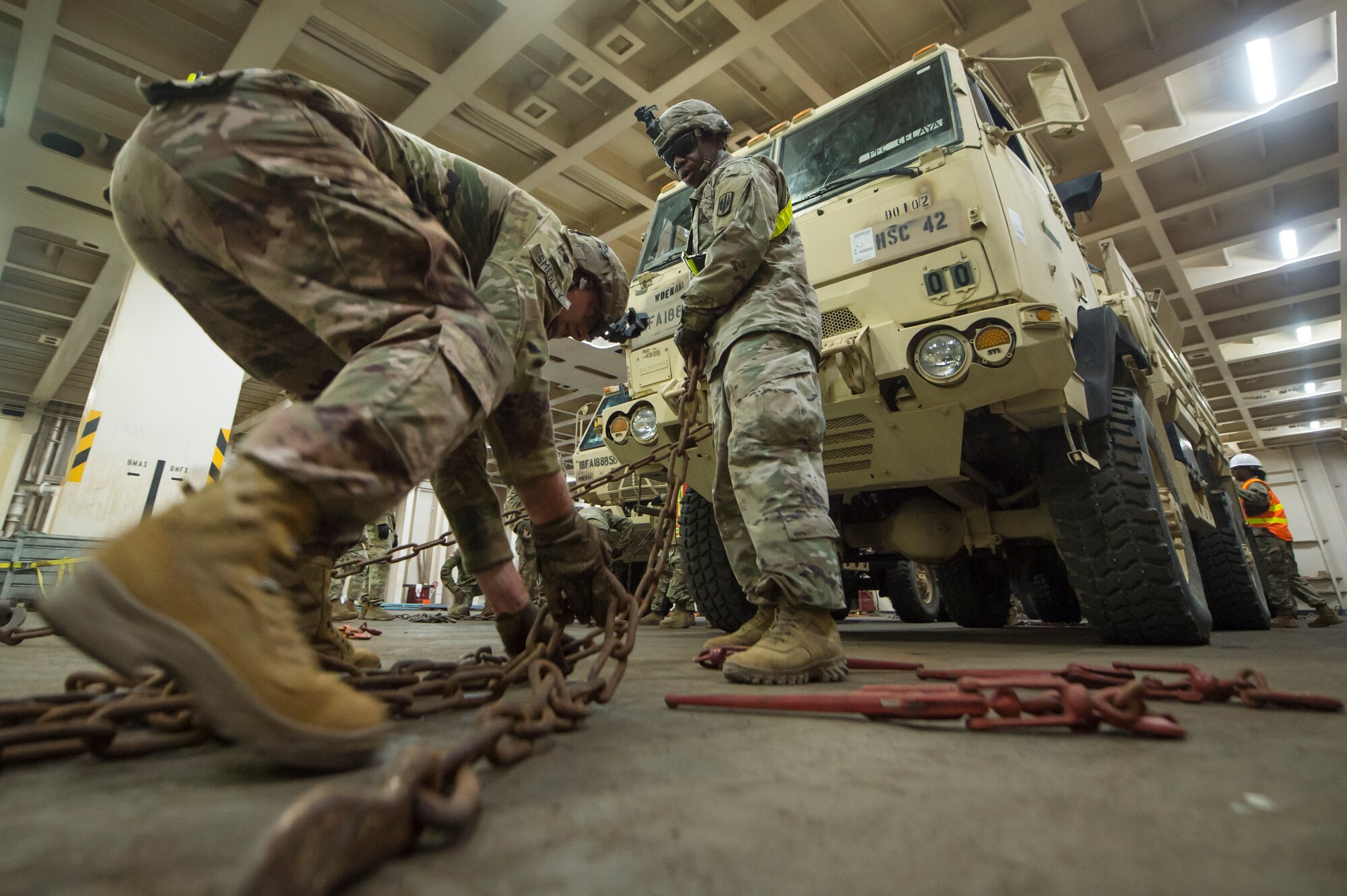 U.S. Army Spc. Robert Smedley, left, and U.S. Army Staff Sgt. Conrad Stewart, both assigned to the 18th Field Artillery Brigade, 188th Brigade Support Battalion from Fort Bragg, N.C., secure a military vehicle onto the Logistics Naval Vessel Cape Decision during Exercise Dragon Lifeline Aug. 7, 2019, at the Federal Law enforcement Training Center in Charleston, S.C. The exercise provided military personnel with experience needed to support rapid deployment operations across air, land, rail and sea. JB Charleston helps to provide rapid global deployment of personnel and equipment to deployed locations across the globe. The annual exercise is just one of the critical readiness exercises the DOD conducts to maintain a lethal and ready force. (U.S. Air Force photo by Tech. Sgt. Christopher Hubenthal)