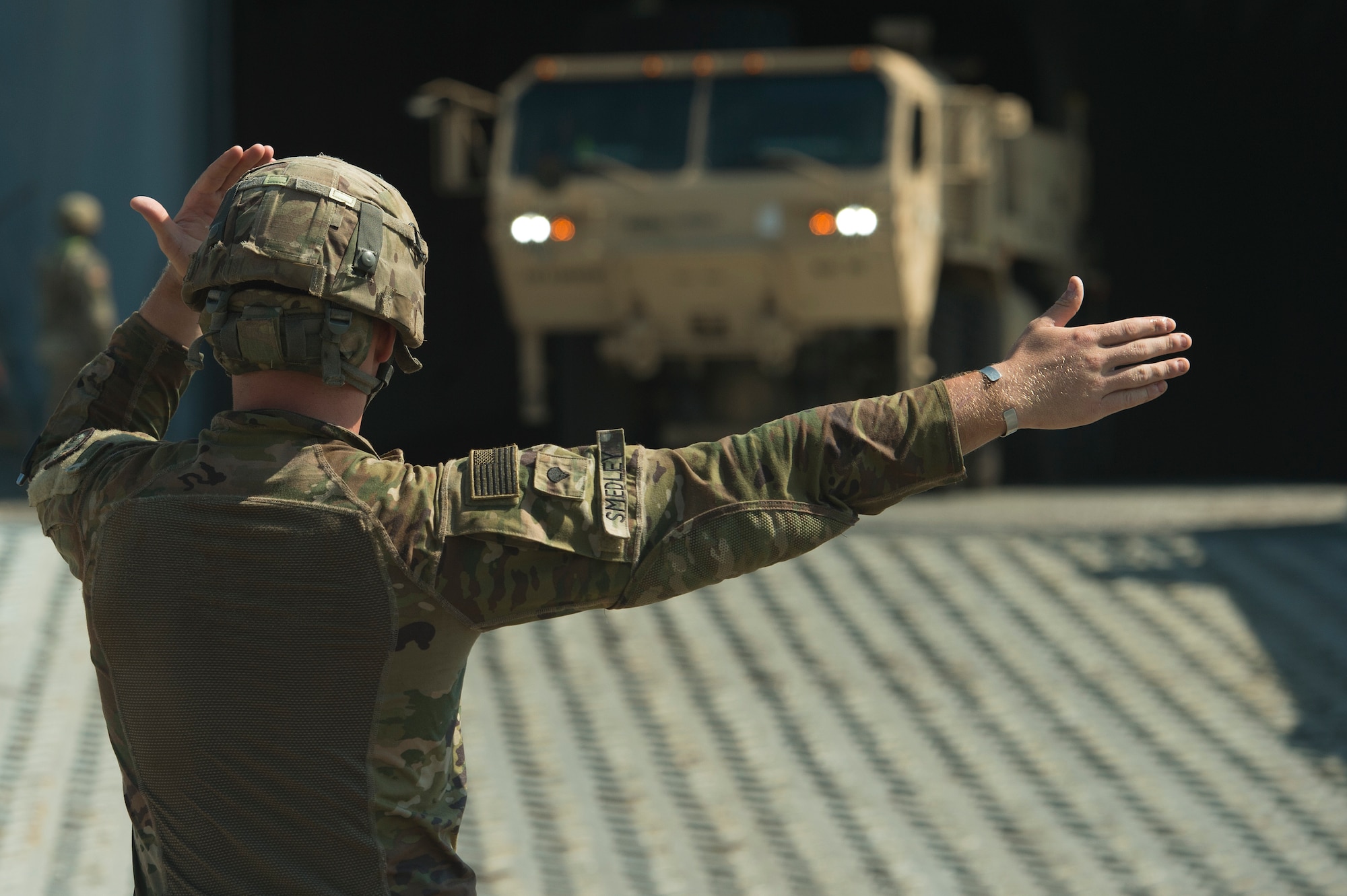 U.S. Army Spc. Robert Smedley, assigned to the 18th Field Artillery Brigade, 188th Brigade Support Battalion from Fort Bragg, N.C., directs military vehicles off Logistics Naval Vessel Cape Decision during Exercise Dragon Lifeline Aug. 7, 2019, at the Federal Law enforcement Training Center, S.C. The deployment readiness exercise combined the capabilities of service members from Fort Bragg, N.C., Joint Base Charleston, S.C., and Joint Base Langley-Eustis, Va., focusing on the rapid deployment of equipment, vehicles and personnel. Participants shared knowledge and tested their efficiency in moving assets by air, land, rail and sea during the training event. The annual exercise is just one of the critical readiness exercises the DOD conducts to maintain a lethal and ready force. (U.S. Air Force photo by Tech. Sgt. Christopher Hubenthal)