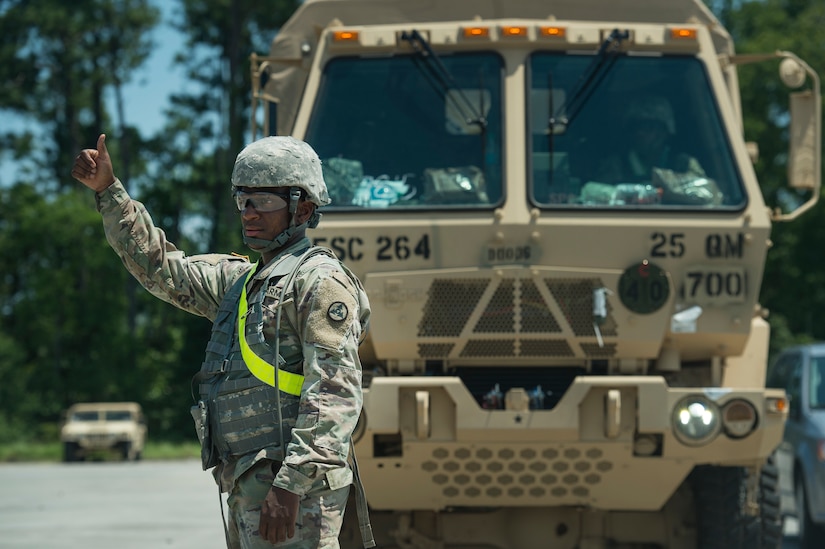 A U.S. Army Soldier signals military vehicles are ready to be onloaded onto a rail system during Exercise Dragon Lifeline Aug. 7, 2019, at Joint Base Charleston’s Naval Weapons Station, S.C. The deployment readiness exercise combined the capabilities of service members from Fort Bragg, N.C., Joint Base Charleston, S.C., and Joint Base Langley-Eustis, Va., focused on the rapid deployment of equipment, vehicles and personnel. Participants shared knowledge and tested their efficiency in moving assets by air, land, rail and sea during the training event. The annual exercise is just one of the critical readiness exercises the DOD conducts to maintain a lethal and ready force. (U.S. Air Force photo by Tech. Sgt. Christopher Hubenthal)
