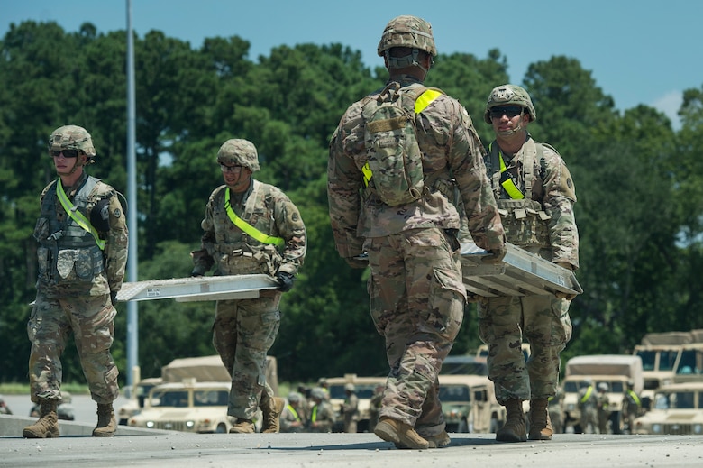 U.S. Army Soldiers from Fort Bragg, N.C., move equipment to prepare a rail system before receiving military vehicles as part of Exercise Dragon Lifeline Aug. 7, 2019, at Joint Base Charleston’s Naval Weapons Station, S.C. The exercise provided military personnel with experience needed to support rapid deployment operations across air, land, rail and sea. JB Charleston helps to provide rapid global deployment of personnel and equipment to deployed locations across the globe. The annual exercise is just one of the critical readiness exercises the DOD conducts to maintain a lethal and ready force. (U.S. Air Force photo by Tech. Sgt. Christopher Hubenthal)