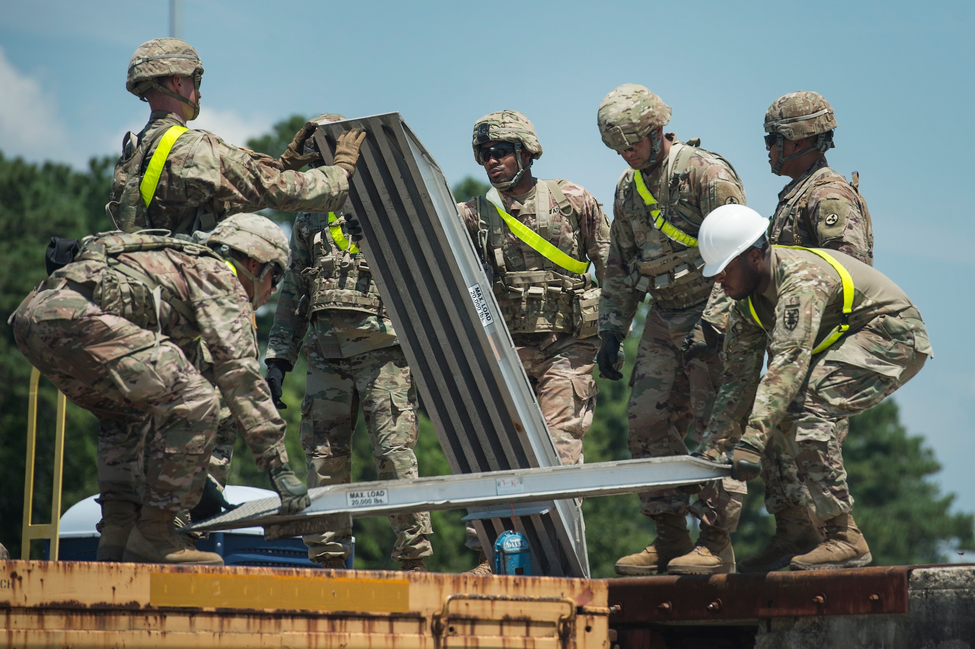 U.S. Army Soldiers from Fort Bragg, N.C., move equipment to prepare a rail system before receiving military vehicles as part of Exercise Dragon Lifeline Aug. 7, 2019, at Joint Base Charleston’s Naval Weapons Station, S.C. The exercise provided military personnel with experience needed to support rapid deployment operations across air, land, rail and sea. JB Charleston helps to provide rapid global deployment of personnel and equipment to deployed locations across the globe. The annual exercise is just one of the critical readiness exercises the DOD conducts to maintain a lethal and ready force. (U.S. Air Force photo by Tech. Sgt. Christopher Hubenthal)