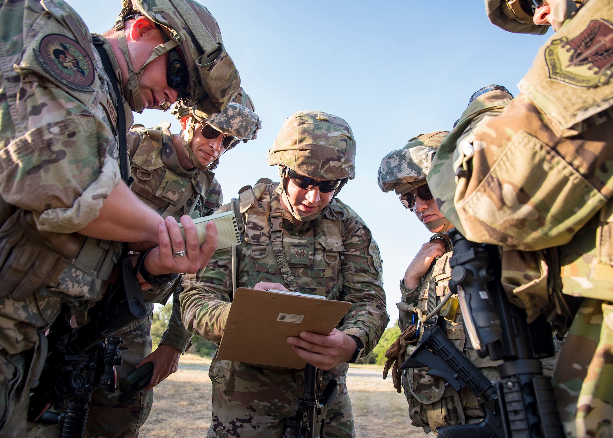 Staff Weather Officers from the 3d Weather Squadron, discuss strategy during a certification field exercise (CFX), July 31, 2019, at Camp Bowie Training Center, Texas. The CFX was designed to evaluate the squadron’s overall tactical ability and readiness to provide the U.S. Army with full spectrum environmental support to the Joint Task Force (JTF) fight. The CFX immersed Airmen into all the aspects of what could come with a deployment such as Land Navigation. (U.S. Air Force photo by Airman 1st Class Eugene Oliver)