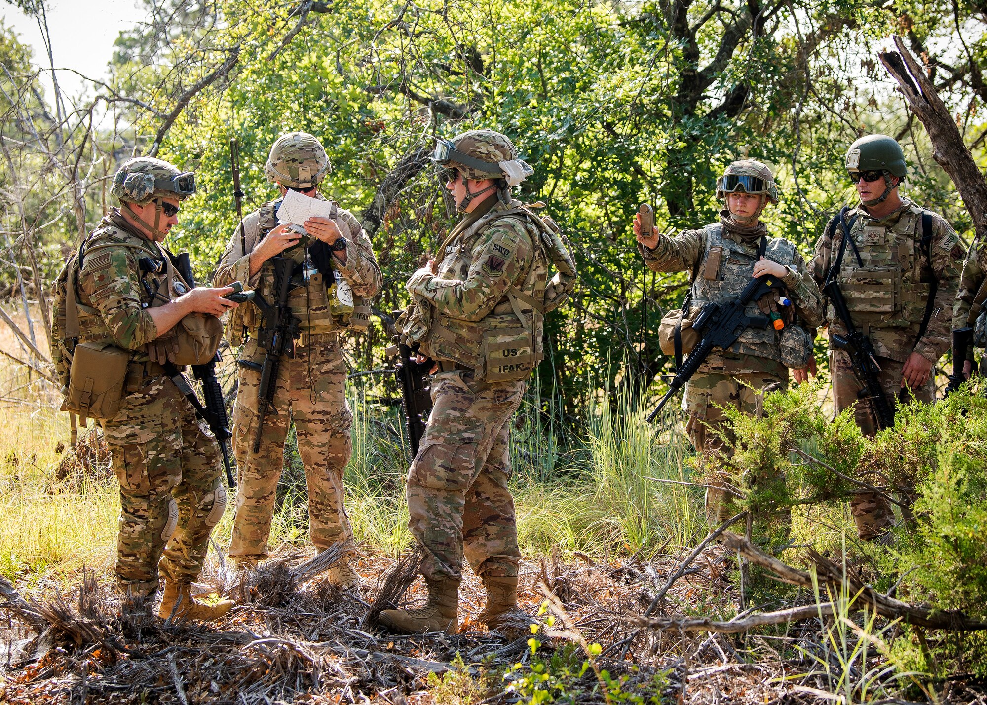 Staff Weather Officers from the 3d Weather Squadron, discuss strategy during a certification field exercise (CFX), July 31, 2019, at Camp Bowie Training Center, Texas. The CFX was designed to evaluate the squadron’s overall tactical ability and readiness to provide the U.S. Army with full spectrum environmental support to the Joint Task Force (JTF) fight. The CFX immersed Airmen into all the aspects of what could come with a deployment such as Land Navigation. (U.S. Air Force photo by Airman 1st Class Eugene Oliver)