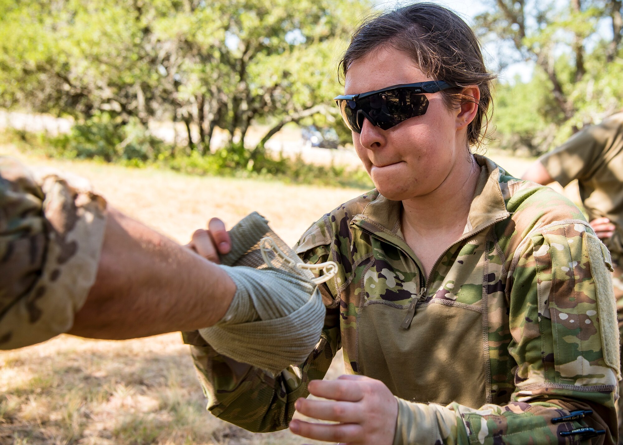 Airman 1st Class Whitley Eyestone, 3d Weather Squadron weather forecaster, applies a tunicate to a simulated victim during a certification field exercise (CFX), July 31, 2019, at Camp Bowie Training Center, Texas. The CFX was designed to evaluate the squadron’s overall tactical ability and readiness to provide the U.S. Army with full spectrum environmental support to the Joint Task Force (JTF) fight. The CFX immersed Airmen into all the aspects of what could come with a deployment such as self-aid buddy care. (U.S. Air Force photo by Airman 1st Class Eugene Oliver)