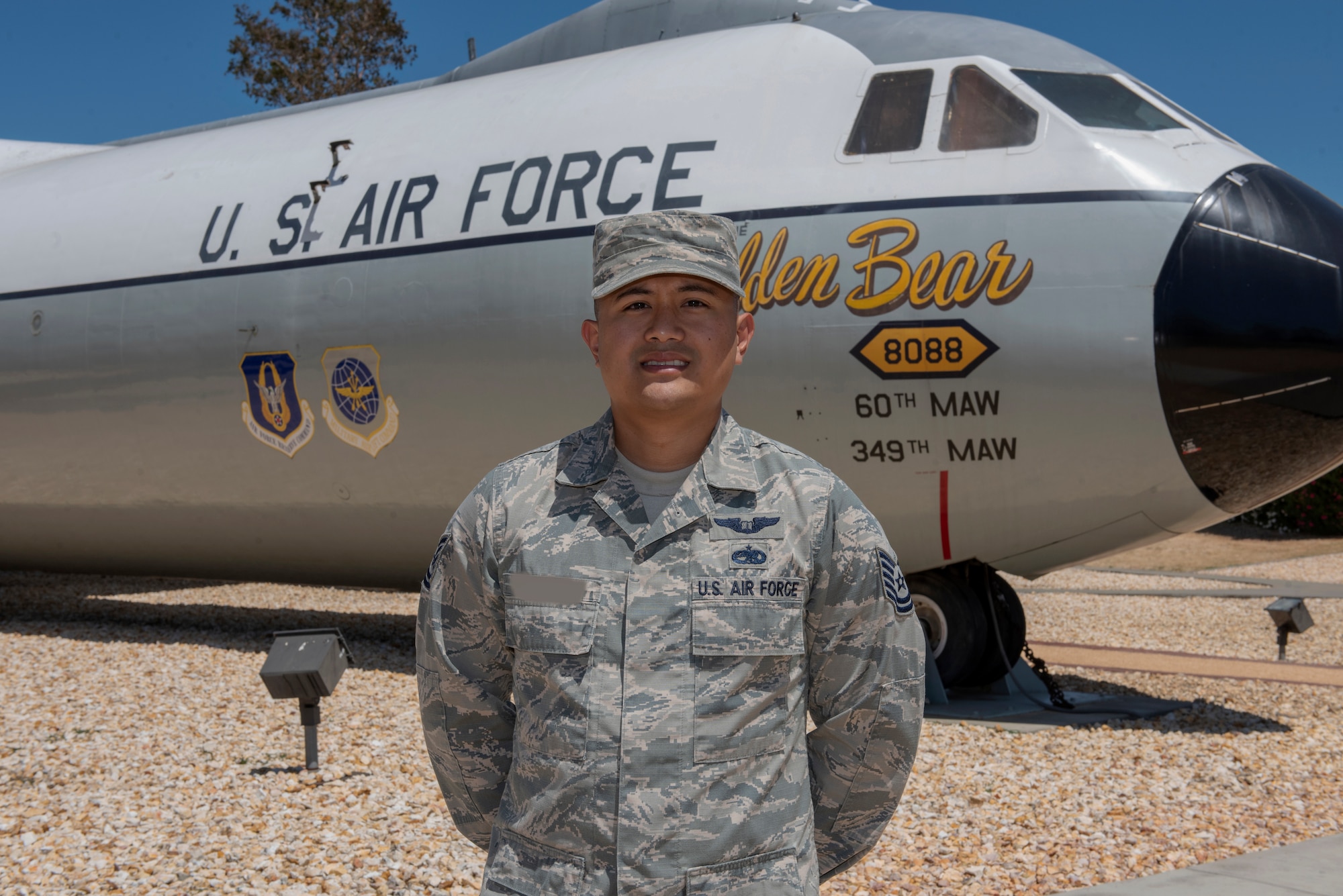 U.S. Air Force Tech. Sgt. Ron, 860th Aircraft Maintenance Squadron flight line expediter, stands in front of a C-141B Starlifter known as the “Golden Bear” July 23, 2019, at Travis Air Force Base, California. Ron completed remote pilot aircraft training July 12 and is one of the few enlisted Airmen the Air Force selected to serve as pilots. This photo has been altered for security purposes by blurring out the last name on the uniform. (U.S. Air Force photo by Tech. Sgt. James Hodgman)