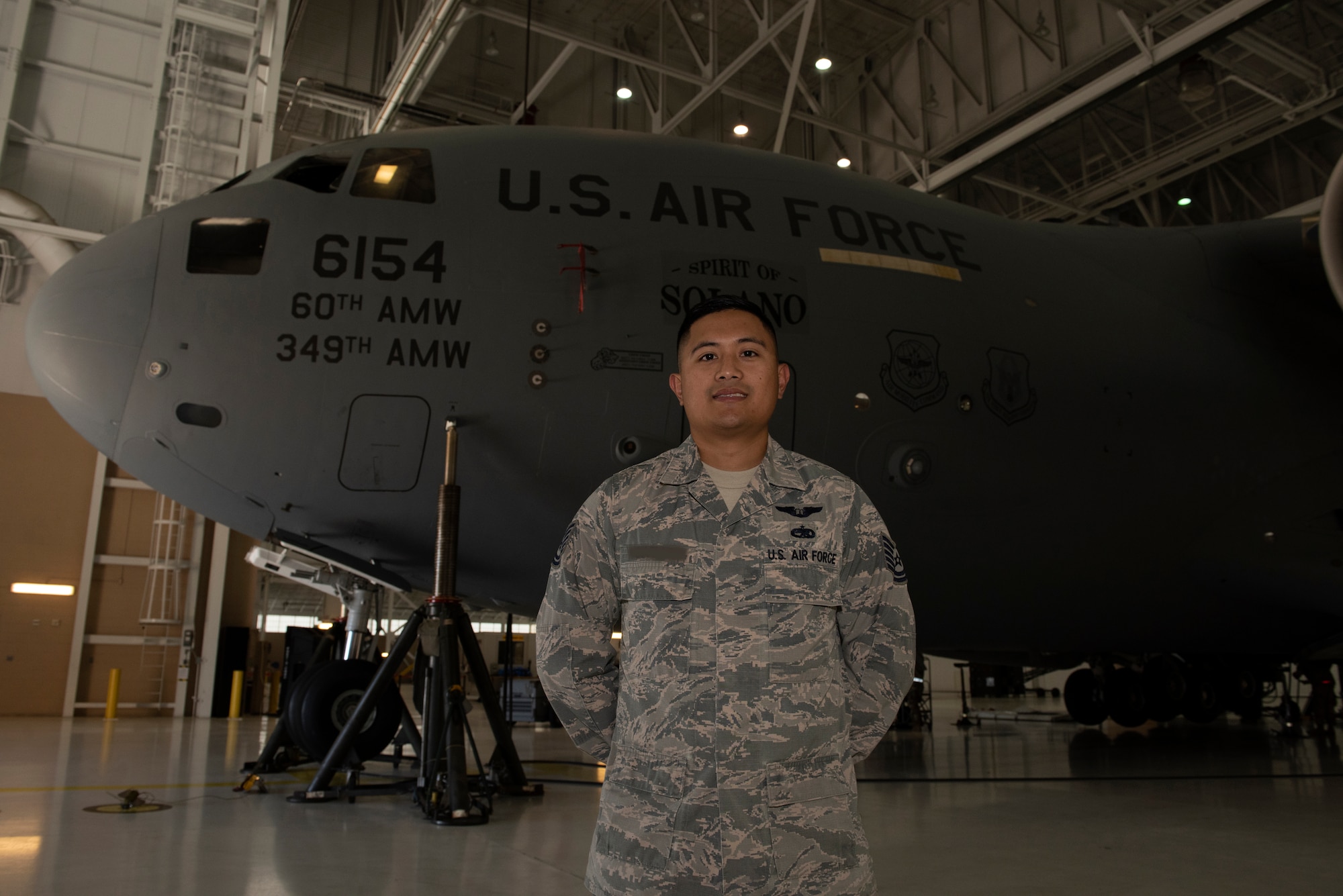 U.S. Air Force Tech. Sgt. Ron, 860th Aircraft Maintenance Squadron flight line expediter, stands in front of a C-17 Globemaster III July 23, 2019, at Travis Air Force Base, California. Ron completed remote pilot aircraft training July 12 and is one of the few enlisted Airmen the Air Force selected to serve as pilots. Prior to being selected to become a pilot, Ron served as a C-17 flying crew chief. This photo has been altered for security purposes by blurring out the last name on the uniform. (U.S. Air Force photo by Tech. Sgt. James Hodgman)