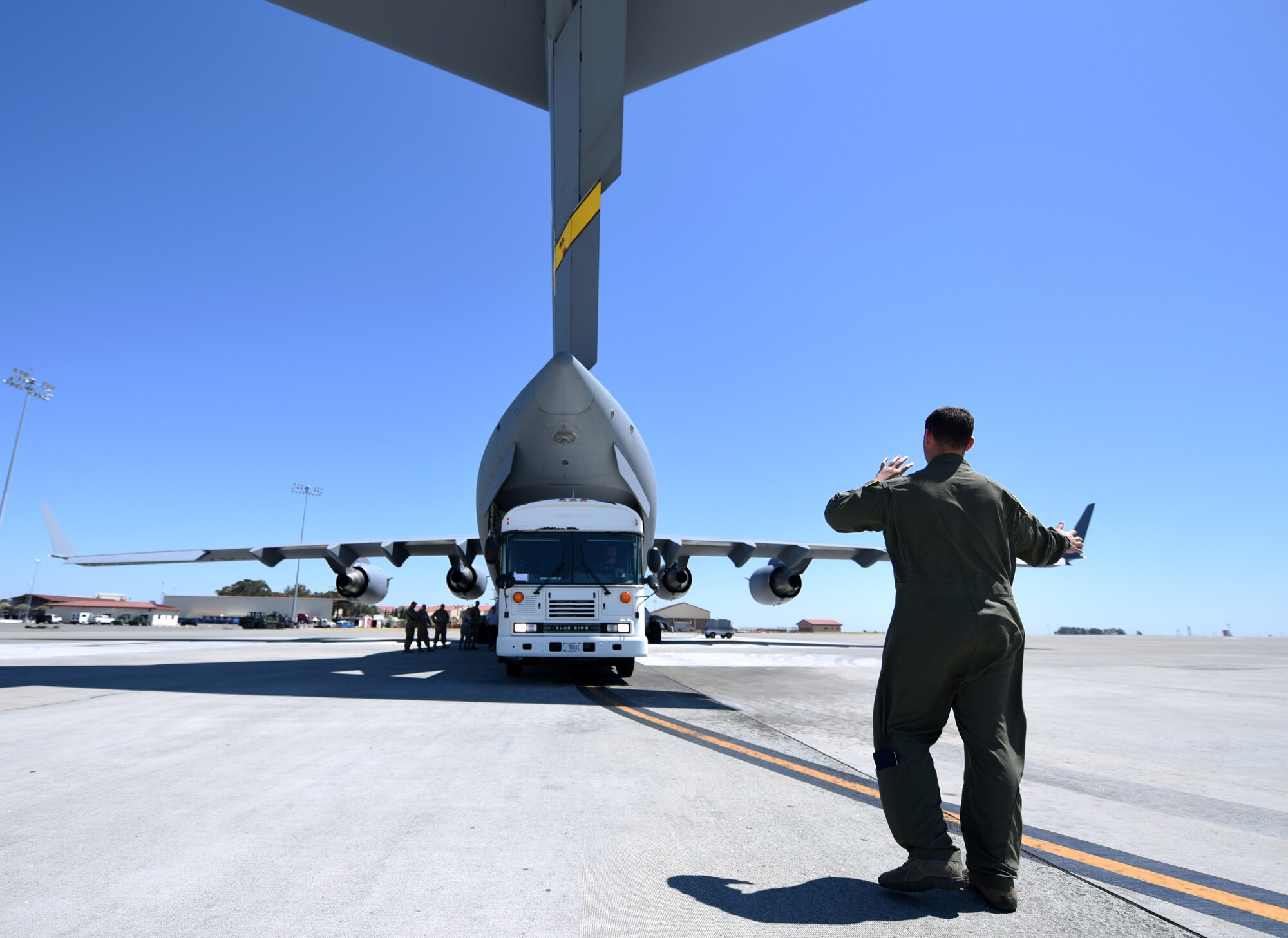 An Airman from March Reserve Base, California, directs the load of a simulated ambulance into a C-17 Globemaster III aircraft Aug. 1, 2019, at Travis Air Force Base, California. The exercise, despite representing a single aspect of the Air Force mobility mission, was an opportunity to encourage joint-force operability between active duty and reserve personnel. (U.S. Air Force photo by Senior Airman Christian Conrad)