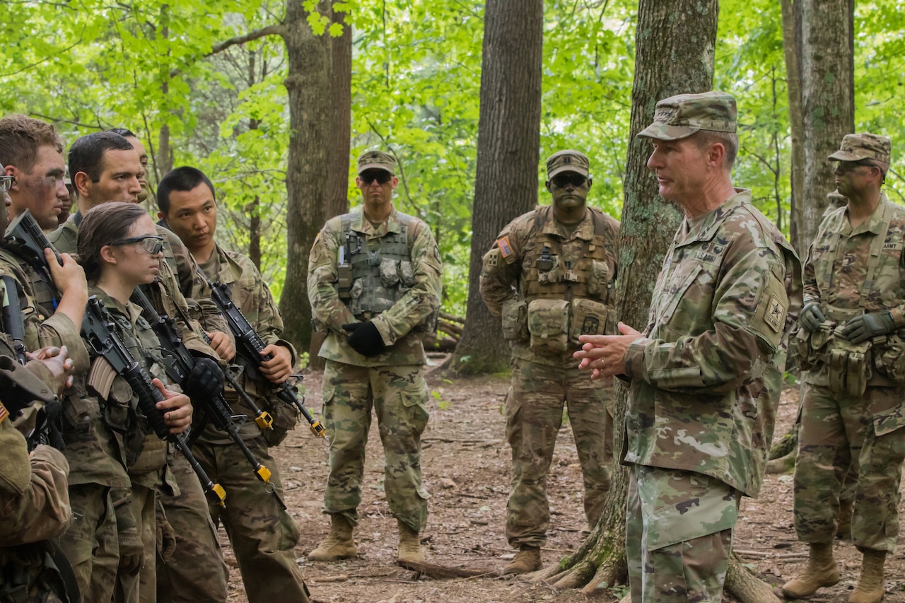 Man speaks to troops in the field.
