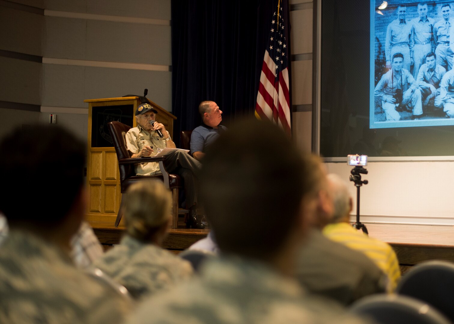 U.S. Army Air Corps 1st Lt. (ret) Raymond Firmani, World War II B-17 pilot, left and Mr. Mitchell Topal, 166th Airlift Wing public affairs specialist, right, speak to the crowd during a Hangar Talk at New Castle Air National Guard Base Del., Aug. 10, 2019. Firmani served as a B-17 pilot and flew 25 combat missions during World War II in 1944 and 1945. (U.S. Air National Guard Photo by Staff Sgt. Katherine Miller)