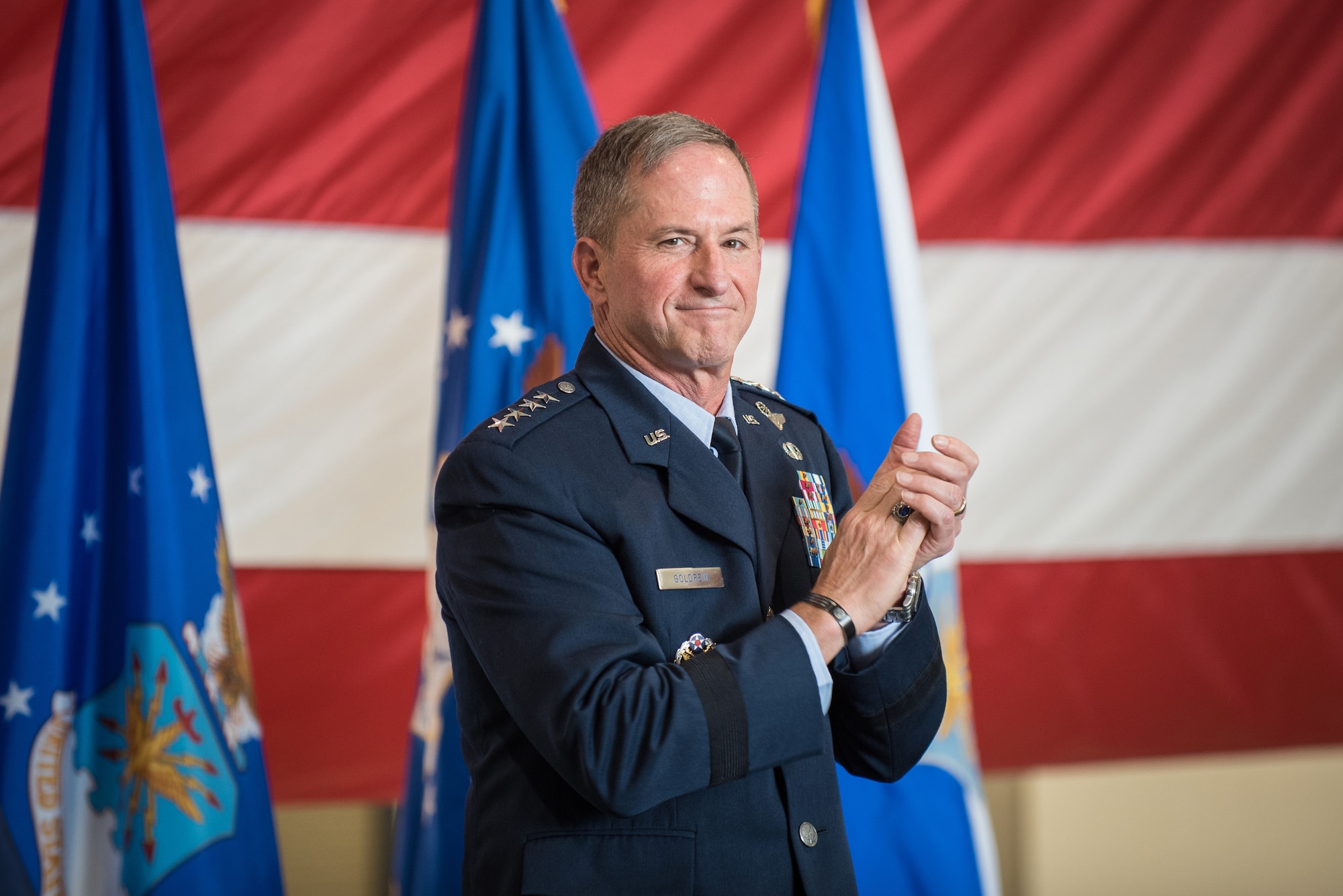 Air Force Chief of Staff Gen. David L. Goldfein applauds Lt. Col. John "J.T." Hourigan during a ceremony to award the Distinguished Flying Cross to Hourigan at the Kentucky Air National Guard Base in Louisville, Ky., Aug. 10, 2019. The 123rd Airlift Wing pilot earned the medal for decisive action following a catastrophic mechanical failure while flying a C-130 Hercules during a routine training sortie, saving the lives of six crew members and a $30 million aircraft. (U.S. Air National Guard photo by Lt. Col. Dale Greer)