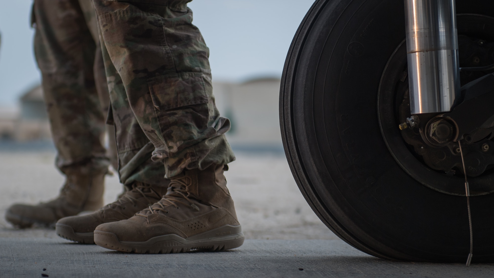 A U.S. Airmen and Soldier stand next to the landing gear of a U.S. Army UH-60 Black Hawk helicopter during a joint inspection of the aircraft at Ali al Salem Air Base, Kuwait, Aug. 9, 2019. Service members assigned to the 386th Expeditionary Logistics Readiness Squadron and the 8-229th Assault Helicopter Battalion inspect the Black Hawks to ensure they're airworthy to load onto U.S. Air Force C-17 Globemaster III aircraft. The Black Hawks will then undergo transport to a location within the U.S. Central Command area of responsibility. (U.S. Air Force photo by Tech. Sgt. Daniel Martinez)