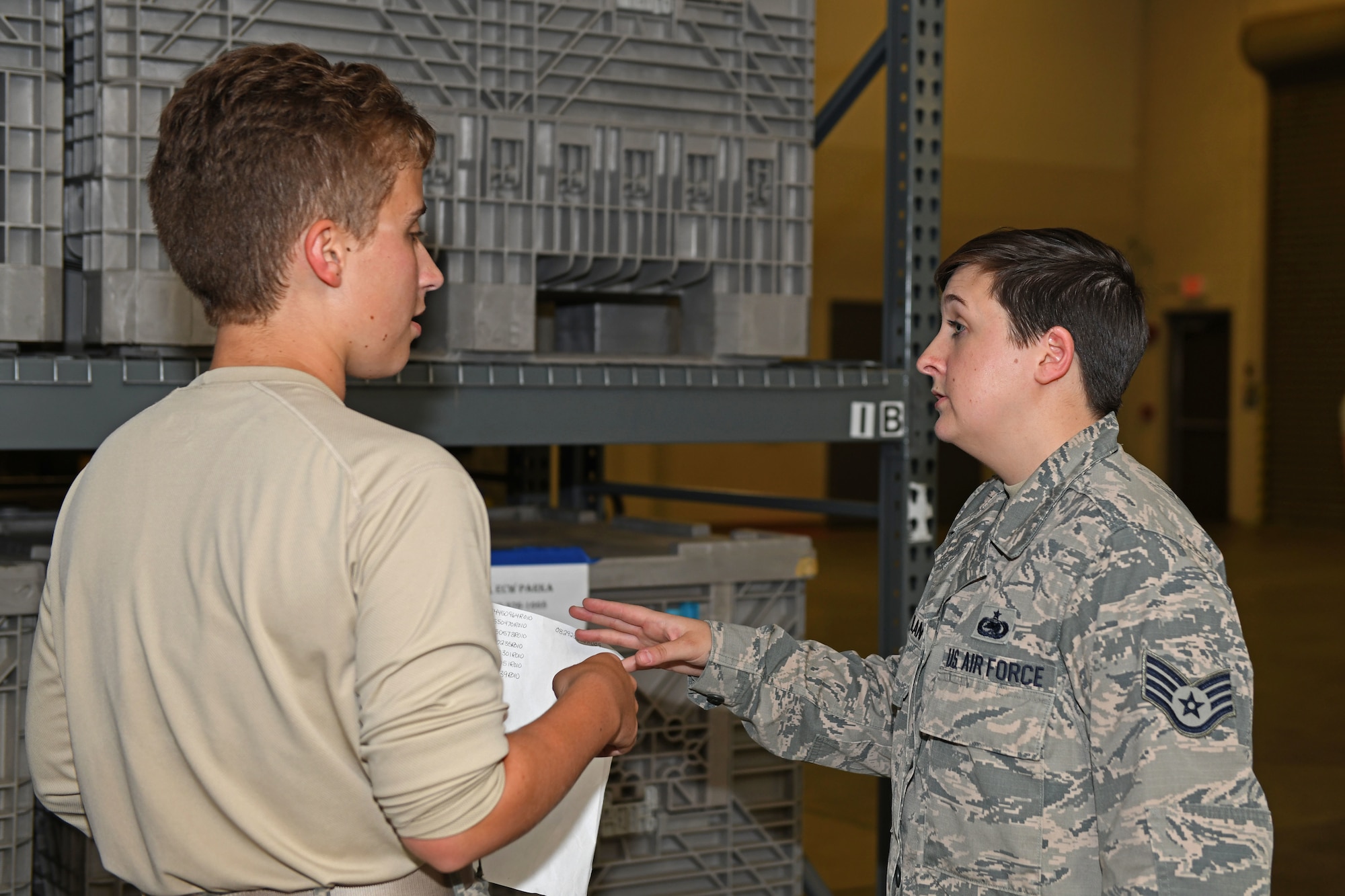 two Airmen discuss information in supply