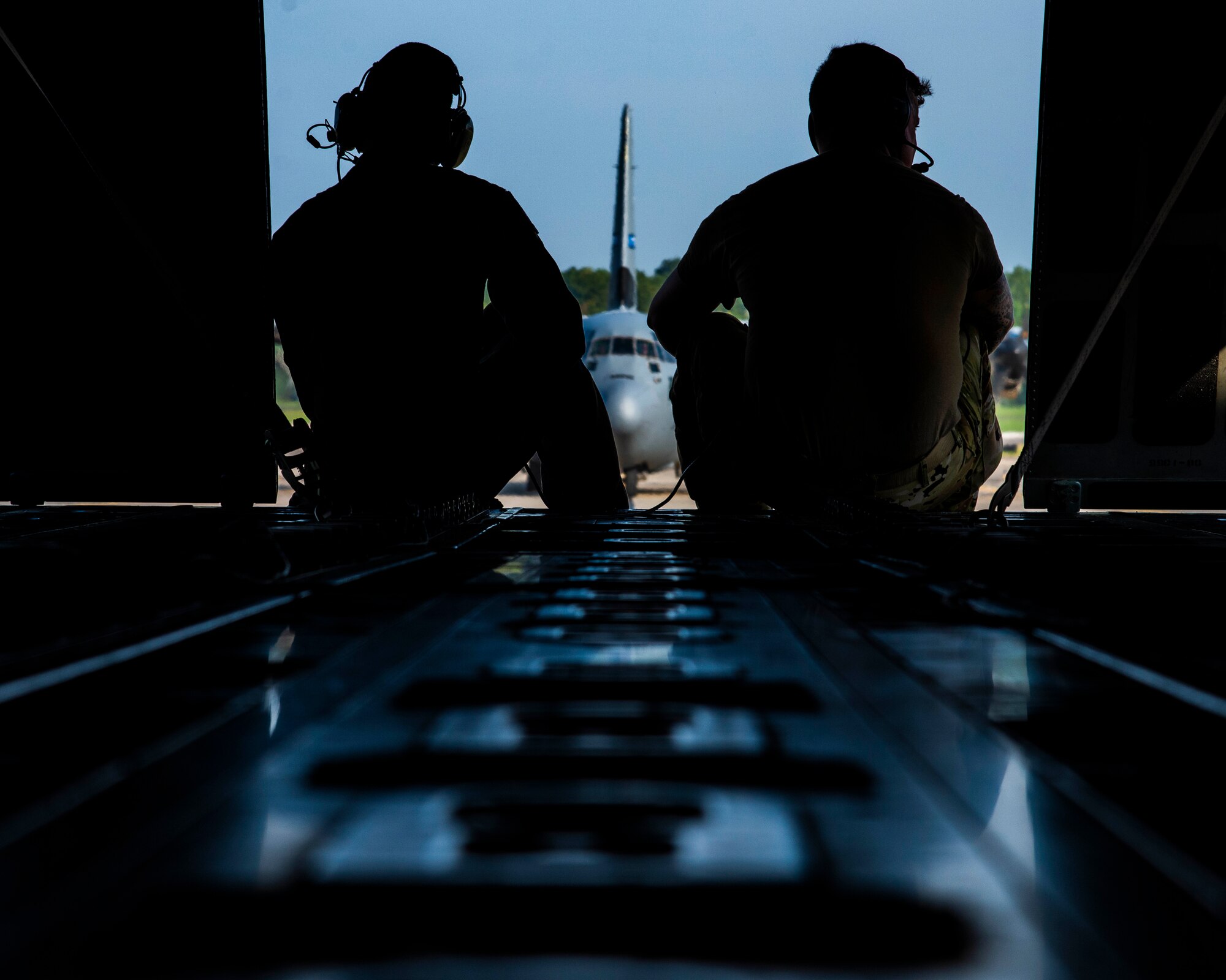 Staff Sgt. Anthony Miller, 327th Airlift Squadron loadmaster (left), and Tech. Sgt. William Mcleod, 327th Airlift Squadron loadmaster (right), ride in the back of a C-130J Hercules as it taxis the runway at Little Rock Air Force Base, Ark. August 7, 2019. The C-130 crew was taking part in a competition called the “turkey shoot.” The first part of the competition is loading and unloading a Humvee for time. Miller was in charge of guiding the Humvee and securing it into the aircraft, while Mcleod was in charge of the cargo drop. The Reserves have one weekend a month, two weeks a year to fulfill training in order to prepare for real world missions and requirements. (U.S. Air Force Reserve Photo by Senior Airman Chase Cannon)
