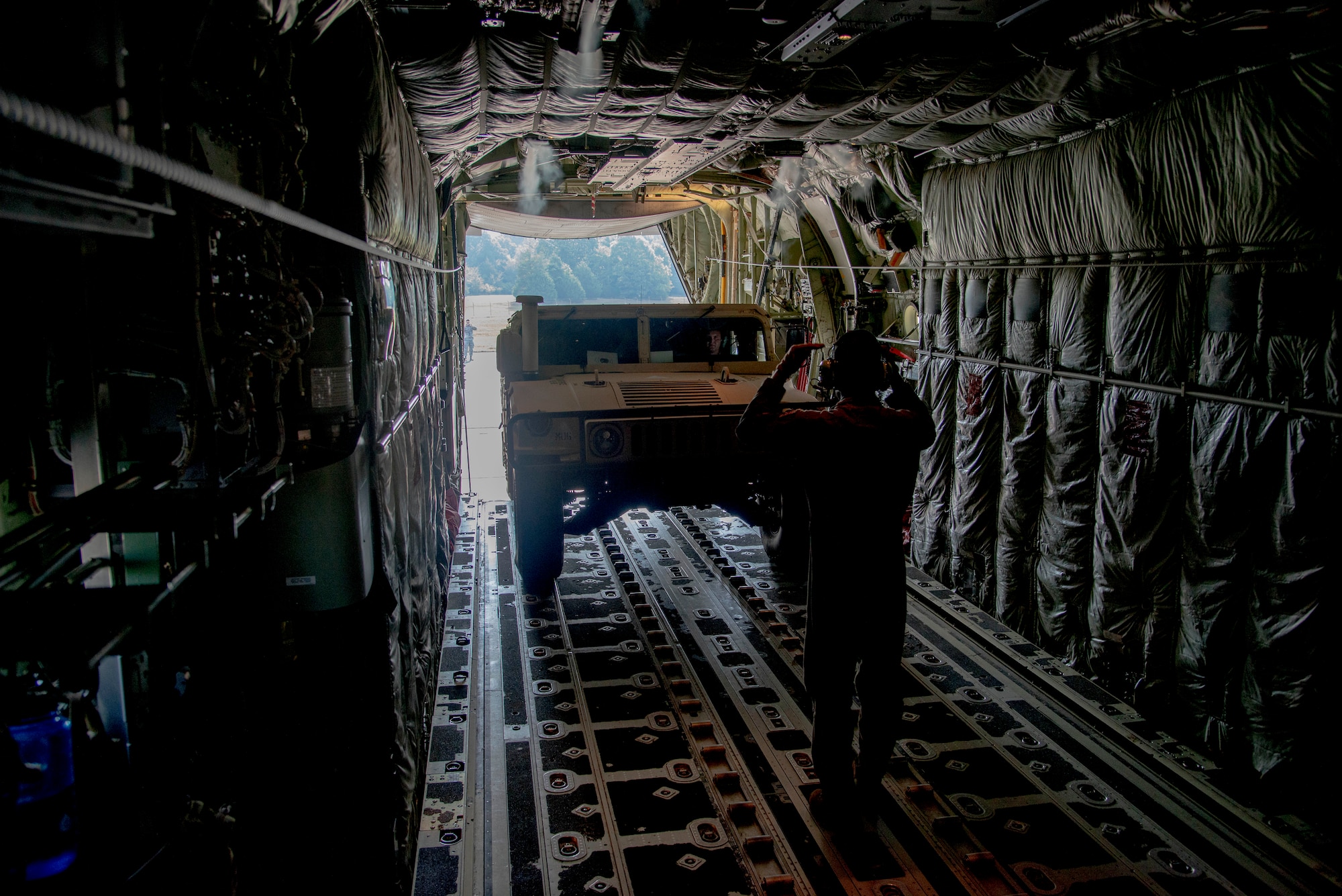 Staff Sgt. Anthony Miller, 327th Airlift Squadron loadmaster, guides a Humvee into a C-130J Hercules during the annual turkey shoot competition at Little Rock Air Force Base, Ark. August 7, 2019. While the competition is a training exercise, it also serves to increase unit cohesion and interoperability between the crews. Mission success depends on Airmen resiliency and their ability to overcome adversity. During the competition, each crew loads a Humvee, completes an assault landing and preforms a small cargo drop. They are scored for timing and accuracy for each of these events. (U.S. Air Force Reserve Photo by Senior Airman Chase Cannon)