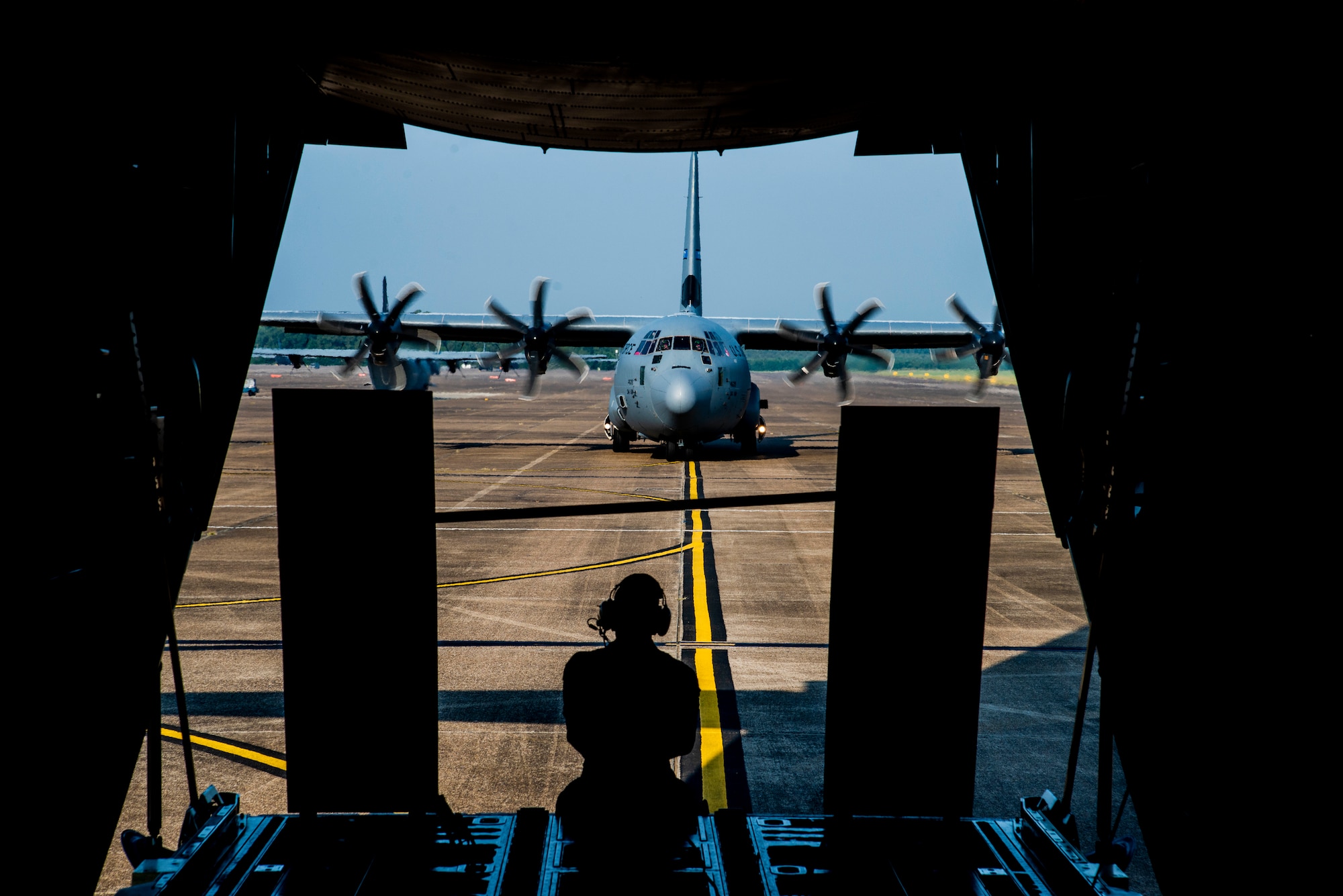 Staff Sgt. Anthony Miller, 327th Airlift Squadron loadmaster, rides in the back of a C-130J as it taxis the runway at Little Rock Air Force Base, Ark. August 7, 2019. The C-130J Hercules crew was taking part in a combat airlift competition called the “turkey shoot.” The first part of the competition is loading and unloading a Humvee for time in which Miller was in charge of guiding the Humvee and securing it into the aircraft. The Reserves have one weekend a month, two weeks a year to fulfill training in order to prepare for real world missions and requirements. (U.S. Air Force Reserve Photo by Senior Airman Chase Cannon)