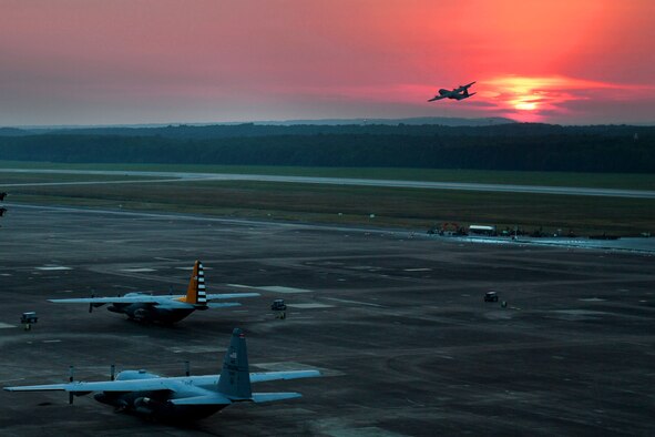 A plane flies at sunset.