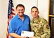 Edwards Air Force Base Civilian-Military Support Group president Al Hoffman presents a $300 check to Command Chief Master Sgt. Ian EISHEN, the 412th Test Wing Command Chief, at the Lancaster Chamber of Commerce in Lancaster, California, Aug. 8. The donation was made on behalf of local singer, "Rat Pack" Ricky Medlin. The money will be used to support the Edwards AFB Youth Center. (U.S. Air Force photo by Danny Bazzell)