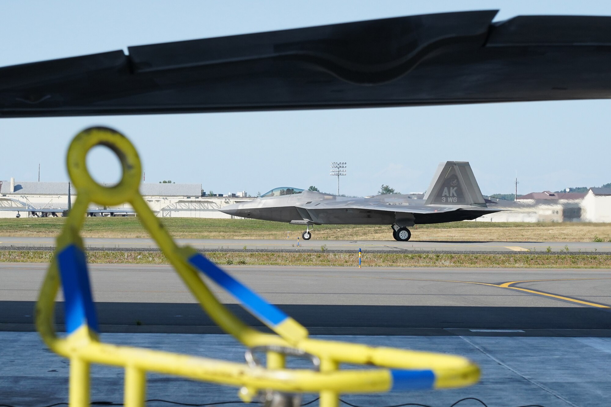 An F-22 Raptor taxis after landing while Airmen assigned to the 673d Logistics Readiness Squadron refuel F-22 Raptors of the 525th Fighter Squadron (the Bulldogs) on Joint Base Elmendorf-Richardson, Alaska, Aug. 9, 2019.  Fuels specialists manage every aspect of the refueling every aircraft on the flight line and are responsible for operating the vehicles, equipment and storage facilities that are essential to refueling operations while ensuring compliance with all safety regulations while handling these volatile liquids.