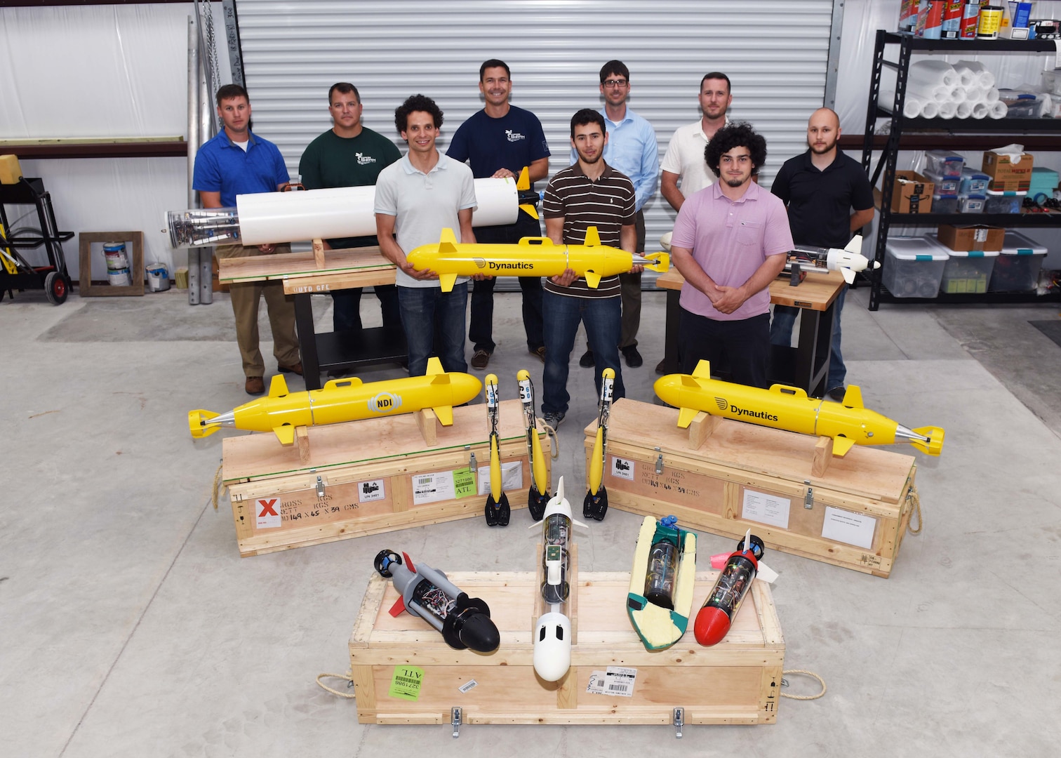 Lead scientists and engineers from Naval Sea Systems Command Warfare Center Divisions pose for a photo as a representation of a collaborative and innovative effort in development of modular, inexpensive unmanned systems collectively known as the “microSwarm Family of Systems,” or “µFOS."