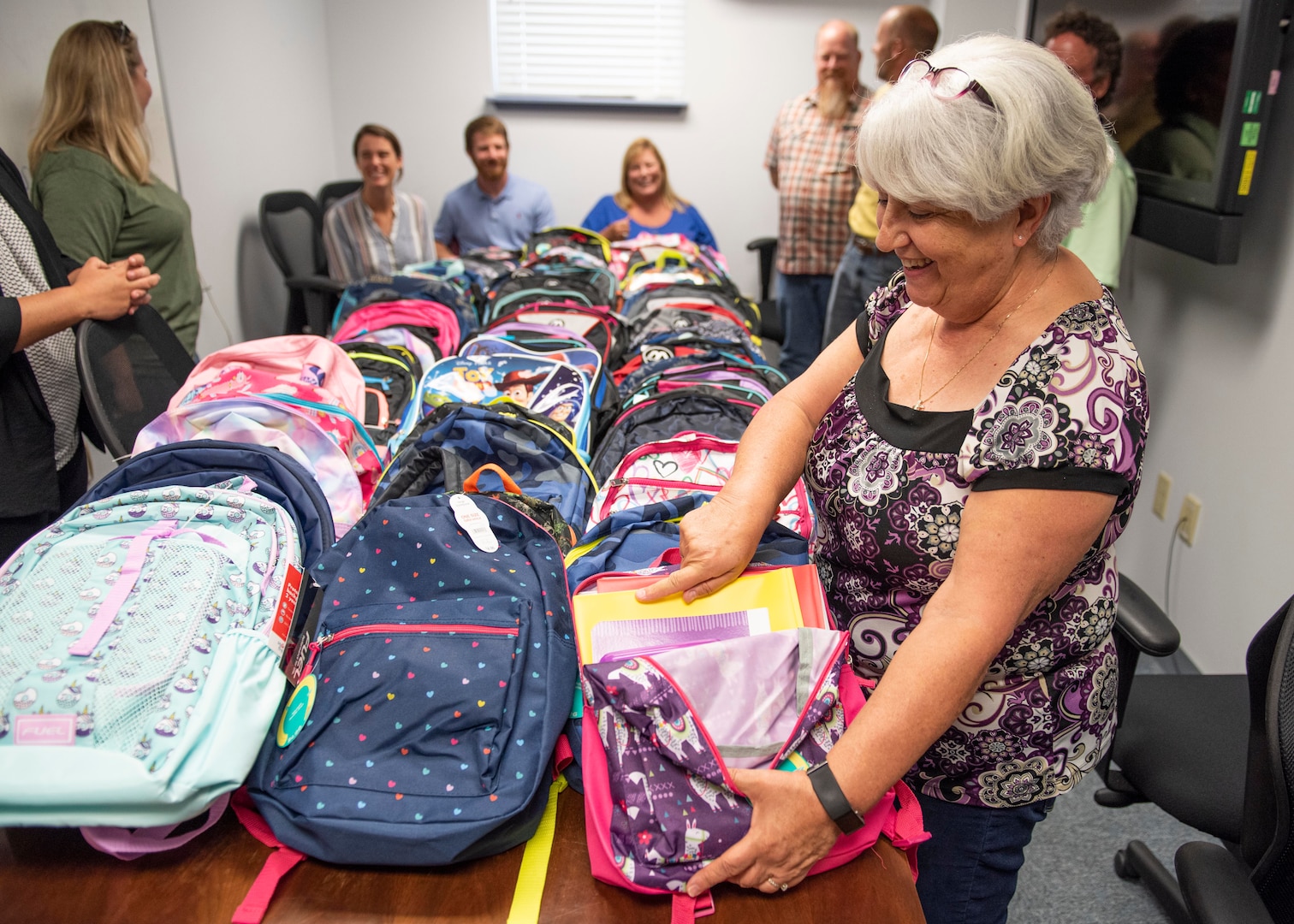 Paula Oliver, administrative assistant at the Naval Surface Warfare Center Panama City Division (NSWC PCD), gathers with other command volunteers to inventory this year’s increase in donations for NSWC PCD’s annual Back to School Supply Drive.