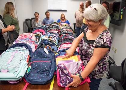 Paula Oliver, administrative assistant at the Naval Surface Warfare Center Panama City Division (NSWC PCD), gathers with other command volunteers to inventory this year’s increase in donations for NSWC PCD’s annual Back to School Supply Drive.