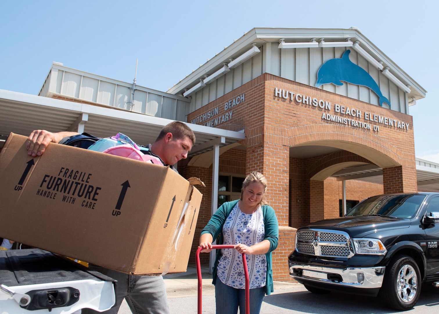 Stephen Carr and Nicole Waters offload donations at Hutchison Beach Elementary School Aug. 8 as part of the Naval Surface Warfare Center Panama City Division’s (NSWC PCD) annual Back to School Supply Drive.