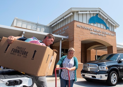 Stephen Carr and Nicole Waters offload donations at Hutchison Beach Elementary School Aug. 8 as part of the Naval Surface Warfare Center Panama City Division’s (NSWC PCD) annual Back to School Supply Drive.