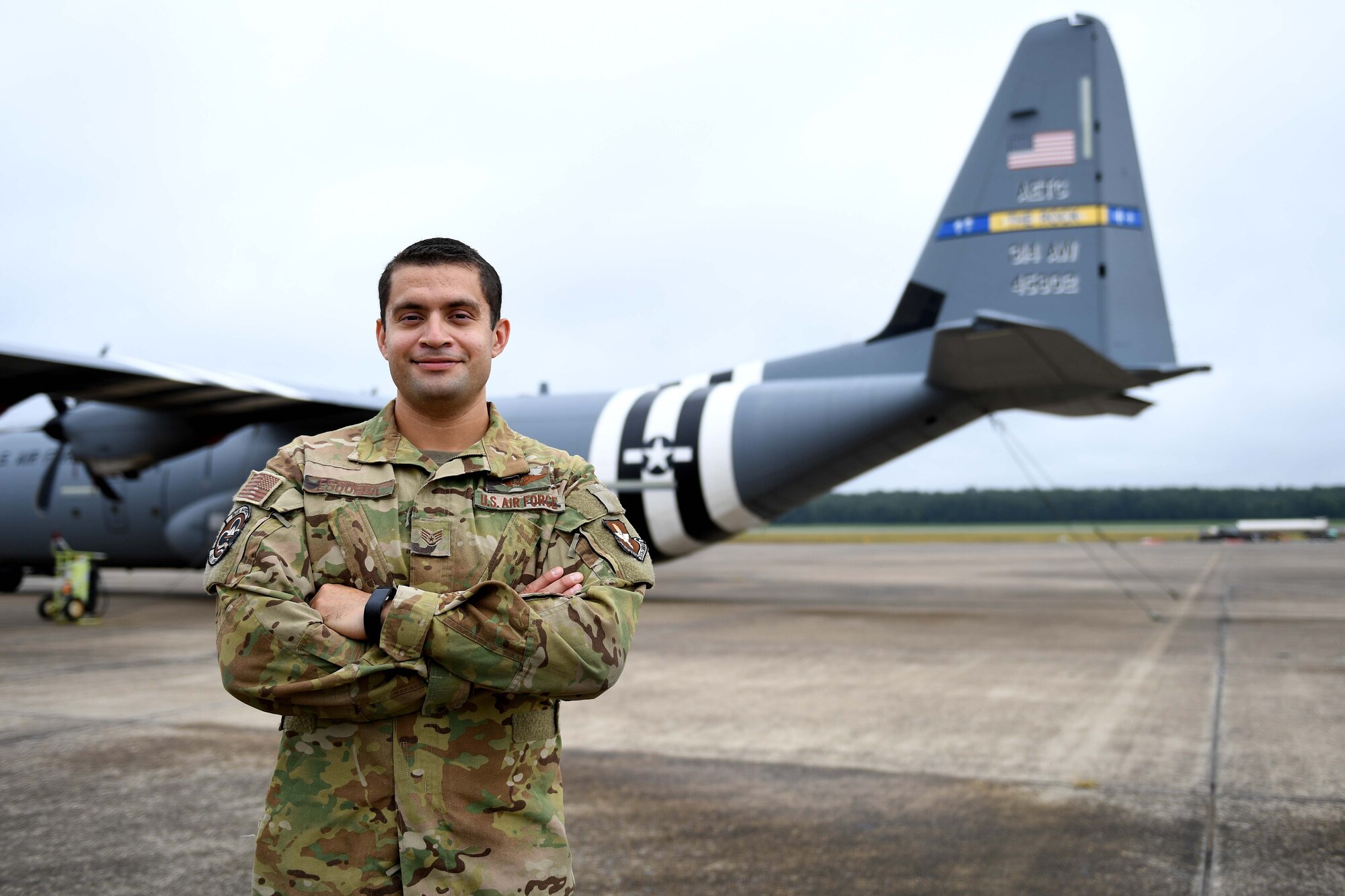 A man stands in front of a C-130J.