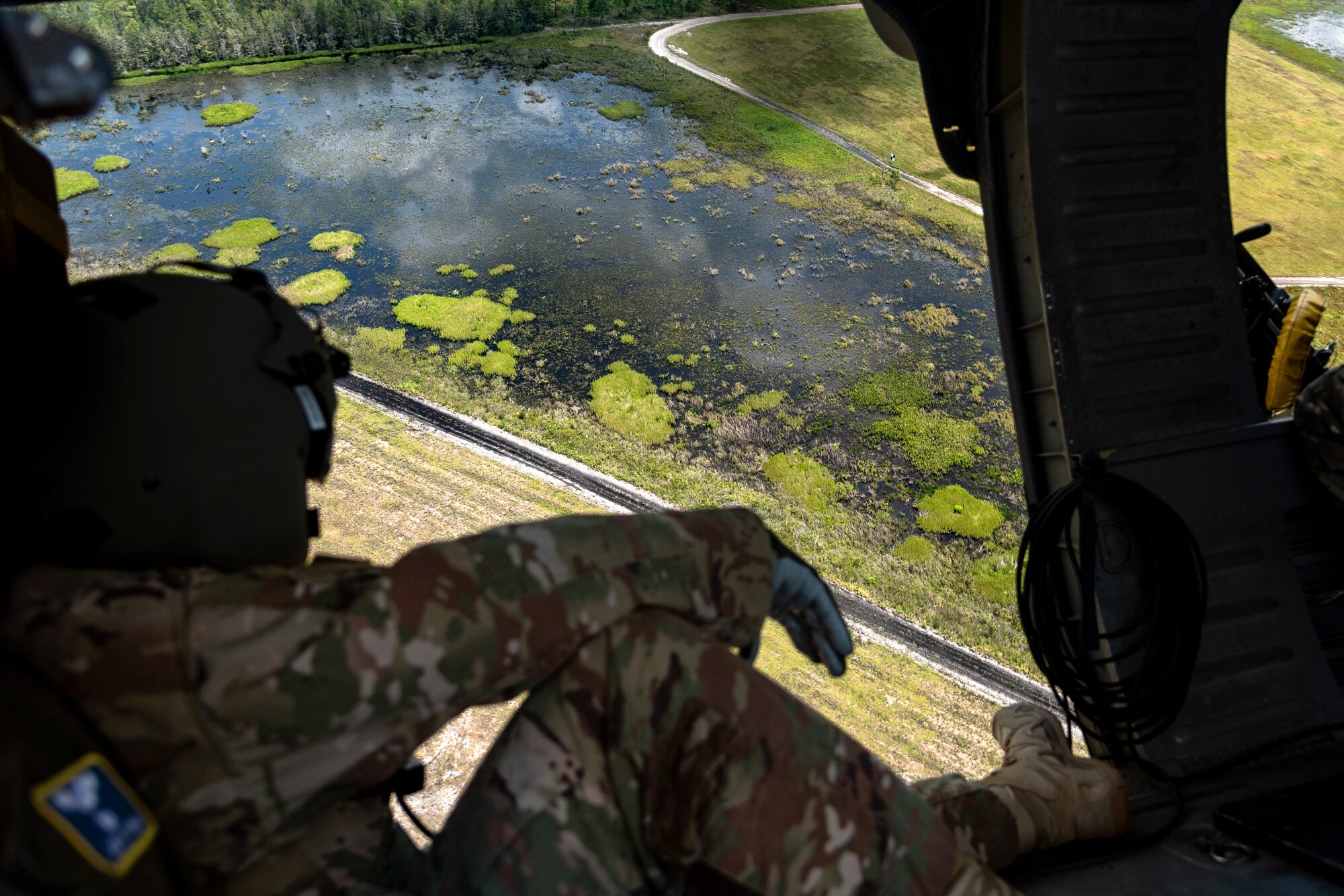 U.S. Air Force Chief Master Sgt. Benjamin Hedden, Ninth Air Force command chief, looks over Grand Bay Range at Moody Air Force Base, Ga., Aug. 8, 2019. Hedden joined U.S. Air Force Maj. Gen. Chad Franks, Ninth Air Force commander, for the initial flight in Franks’ flagship aircraft, an HH-60G Pave Hawk assigned to the 41st Rescue Squadron. Franks, who on separate occasions served as the commander for the 23d Wing and 347th Rescue Group, is a command pilot with more than 3,300 hours in multiple aircraft including HC-130J Combat King II and HH-60G Pave Hawk. (U.S. Air Force photo by Airman 1st Class Taryn Butler)