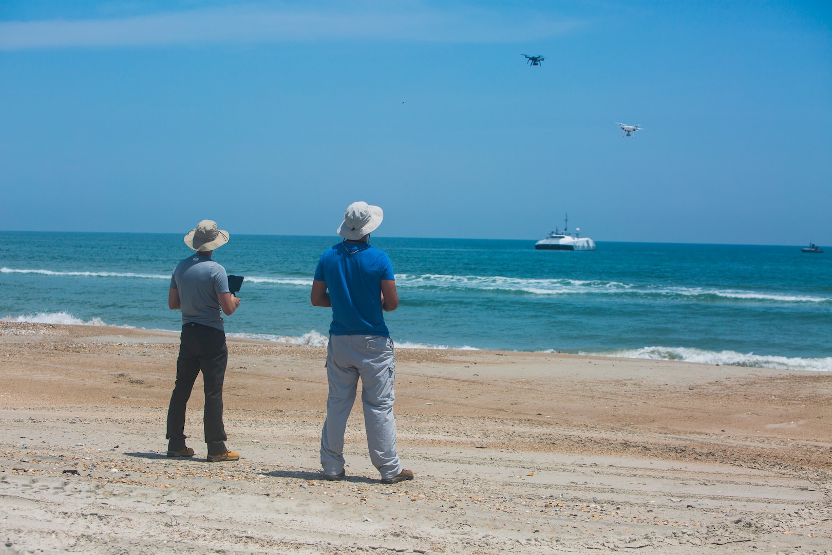 Jared Soltis (left) and Owen McGarity, engineers in the Sea-Based Aviation and Aeronautics Branch (Code 882) at Naval Surface Warfare Center, Carderock Division, pilot unmanned aerial systems (UAS) on July 15, 2019, at the beach on Camp Lejeune, North Carolina, during the Advanced Naval Technology Exercise (ANTX) East. As part of the Red Team, McGarity and Soltis acted as the adversary for counter-UAS technologies that were being demonstrated. (U.S. Marine Corps photo by Cpl. Michael Parks/Released)