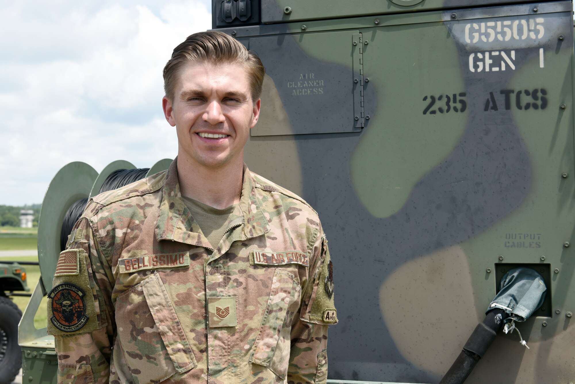 U.S. Air Force Tech. Sgt. James Bellissimo, controller with the 235th Air Traffic Controller Squadron, poses in front of a mobile radar unit set in New London, N.C., Aug. 3rd, 2019. The North Carolina Air National Guard, along with New Hampshire and Maine Air National Guard, flew to Ramstein Air Base, Germany to work with active duty 1st Combat Communications Squadron. The Air National Guard units assisted in training the active duty unit with set-up, use, and tear-down of a mobile tower and deployable tactical air navigation system.
